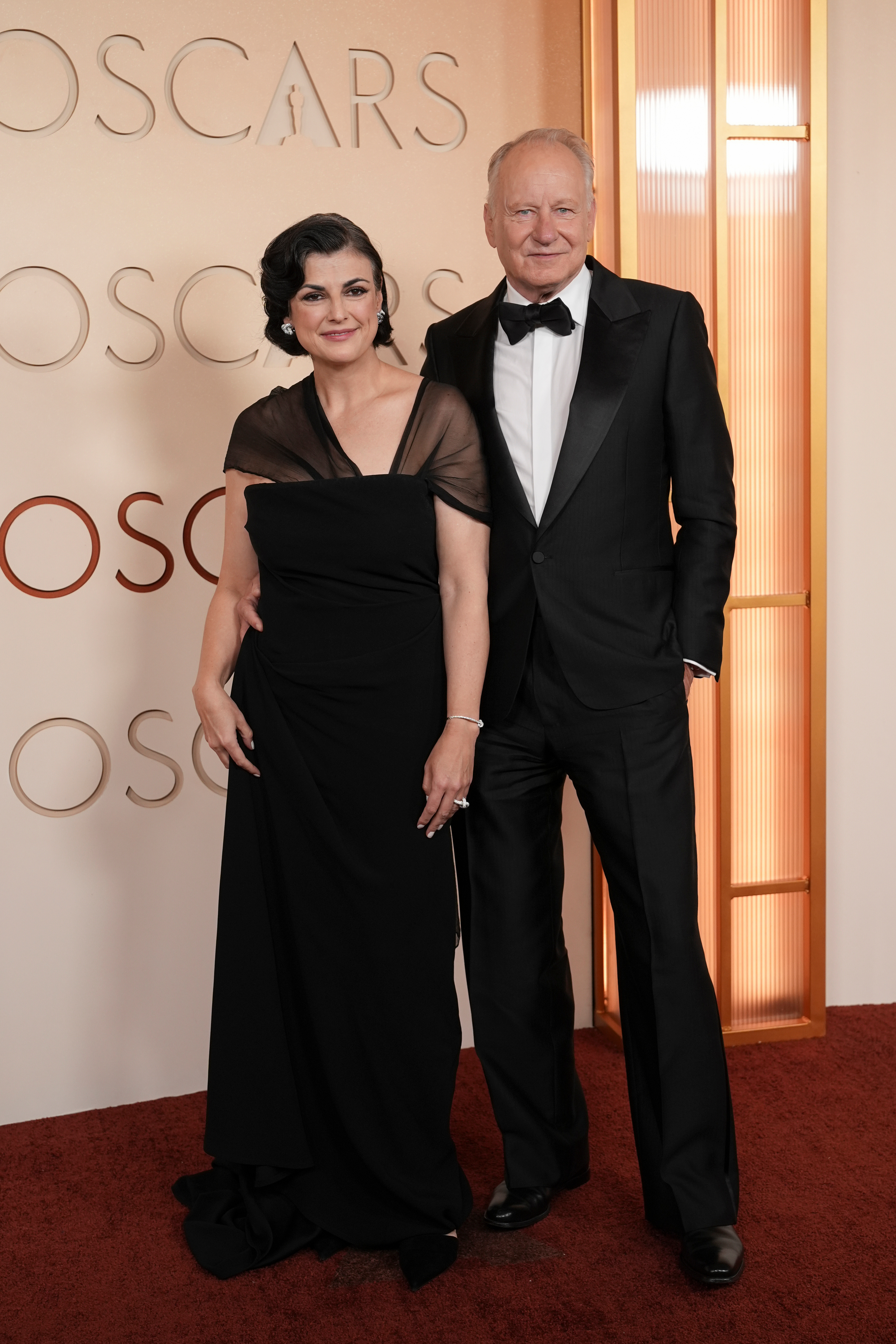 Megan Everett-Skarsgard, left, and Stellan Skarsgård arrive at the Oscars on Sunday, March 15, 2026, at the Dolby Theatre in Los Angeles.