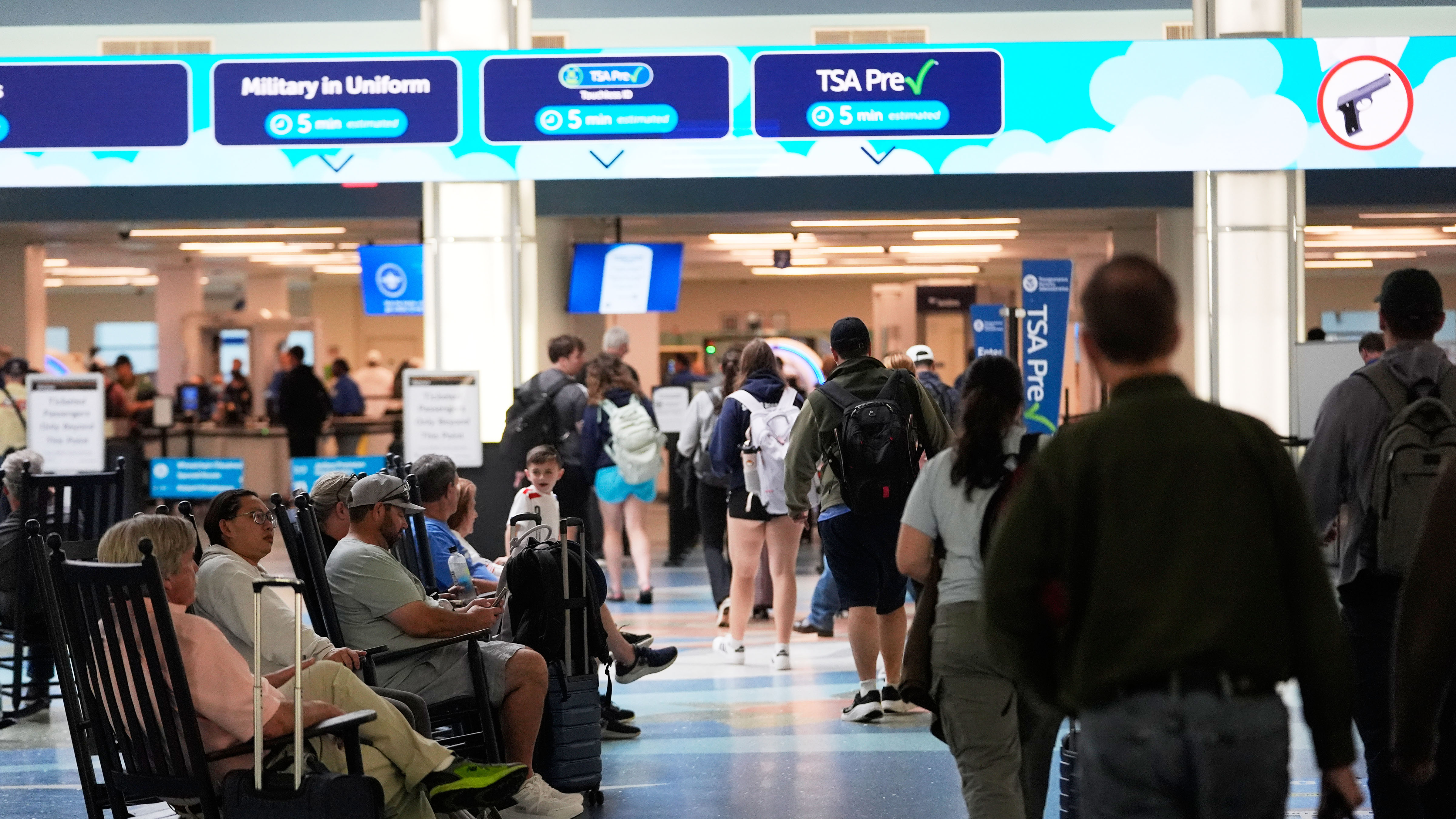 Departing passengers walk towards a TSA screening checkpoint, past those waiting at the Jacksonville International Airport in Jacksonville, Fla., Monday, March 16, 2026.