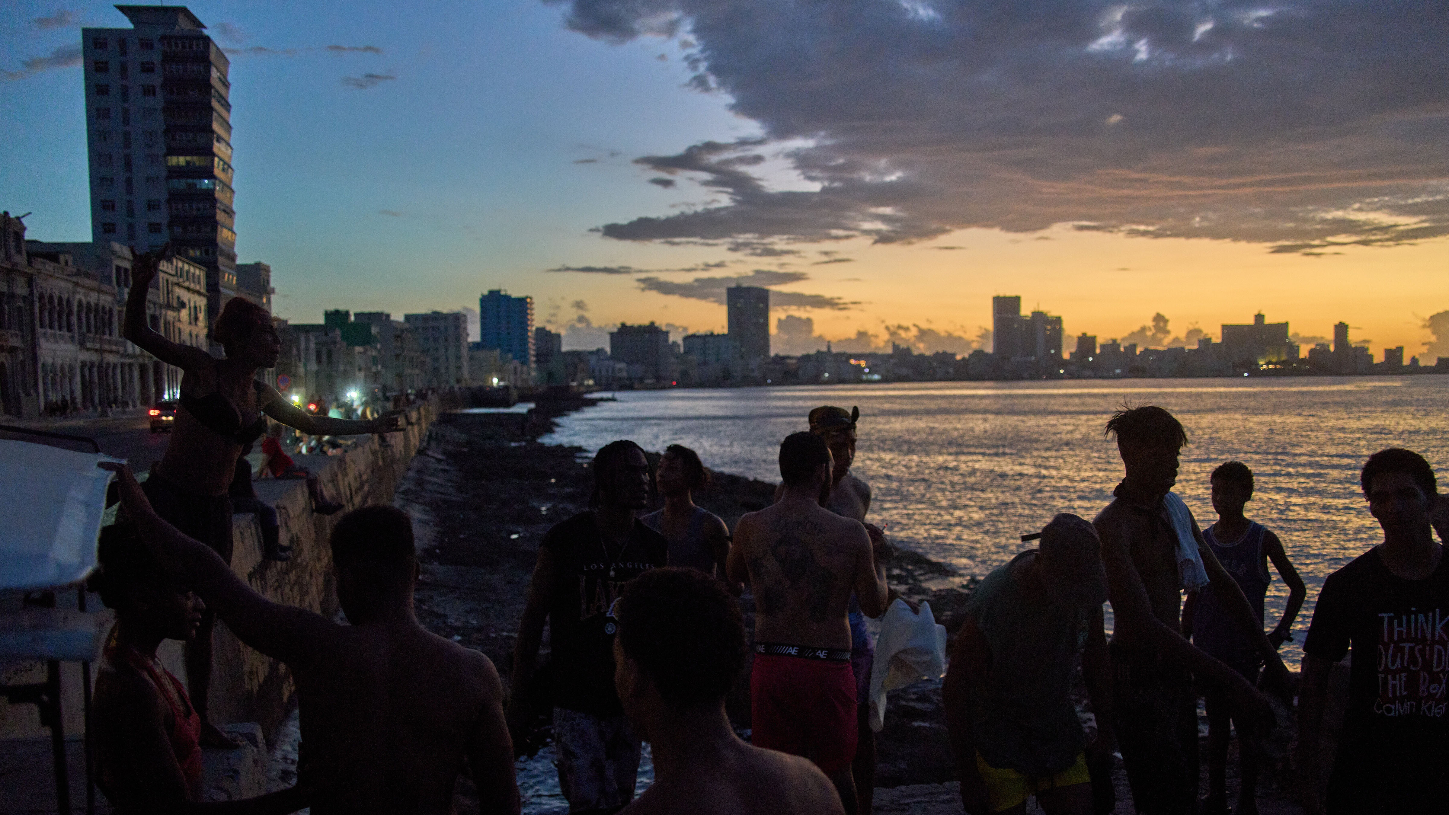 People watch the sunset from the Malecón during a blackout in Havana, Monday, March 16, 2026. 