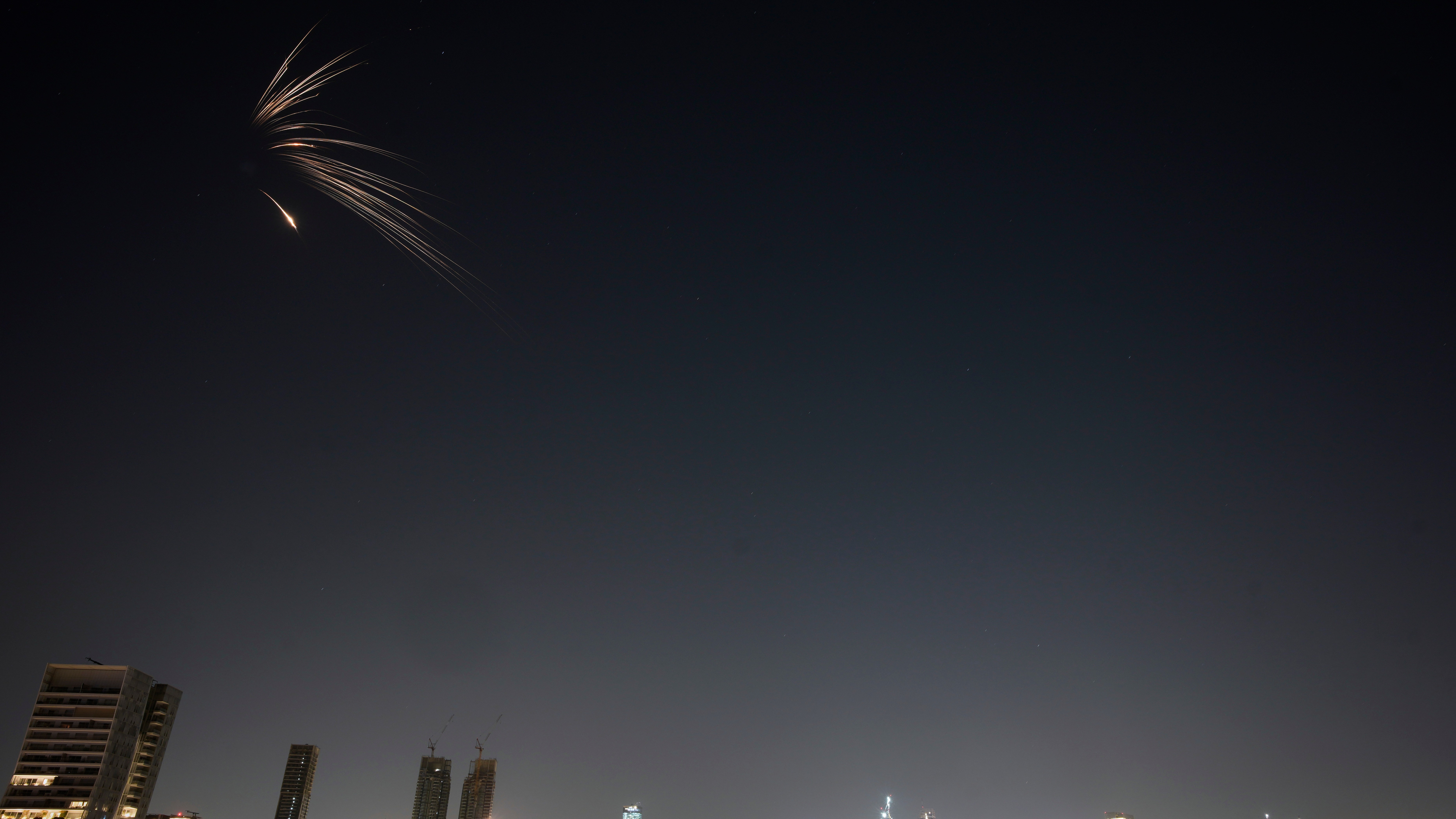 Missiles launched from Iran streak across the sky over central Israel, early Wednesday, March 18, 2026.