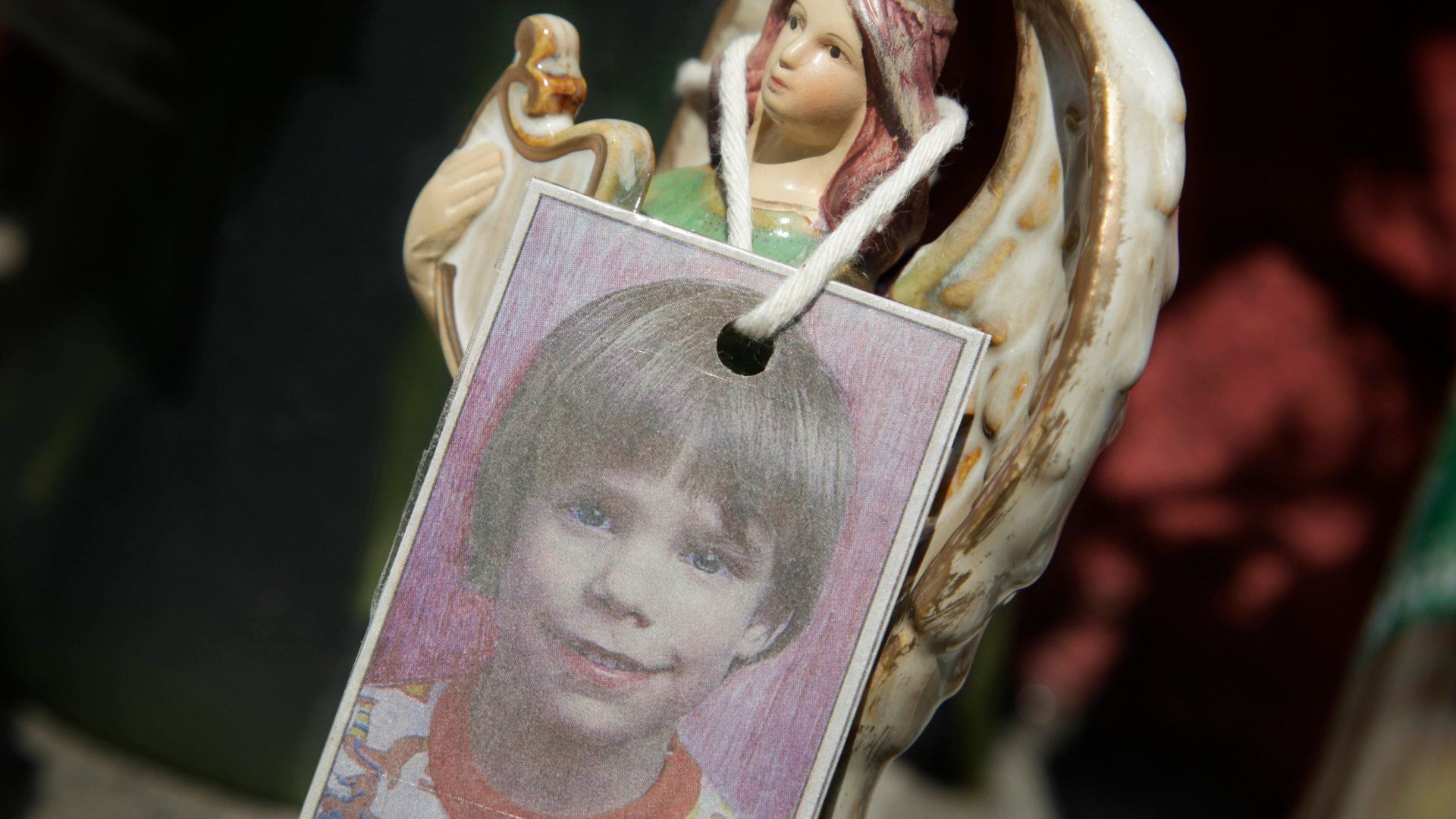 FILE - A photograph of Etan Patz hangs on an angel figurine, as part of a makeshift memorial in New York, May 28, 2012.