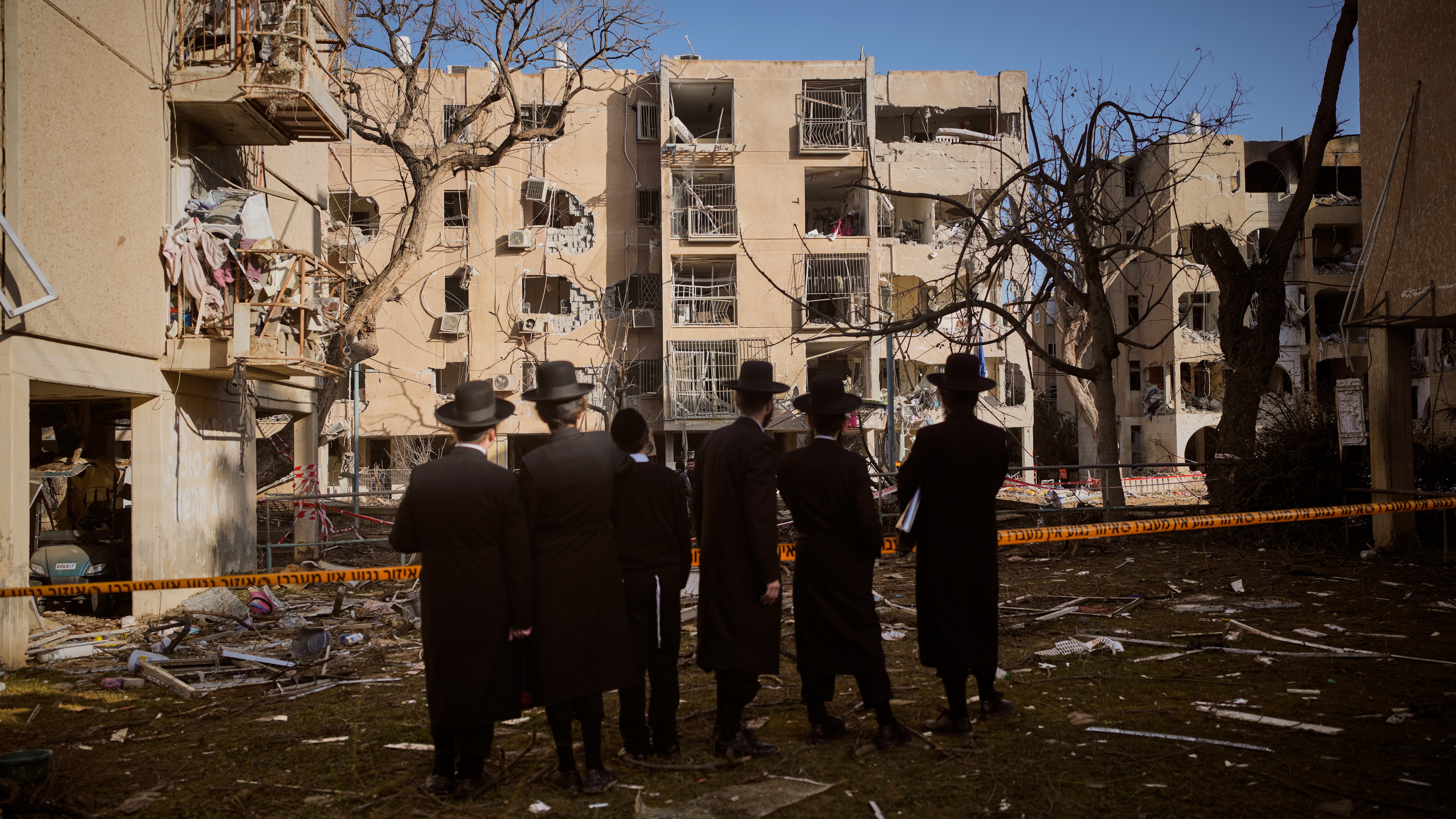 People look at residential buildings damaged by an Iranian missile strike in Arad, southern Israel, Sunday, March 22, 2026.