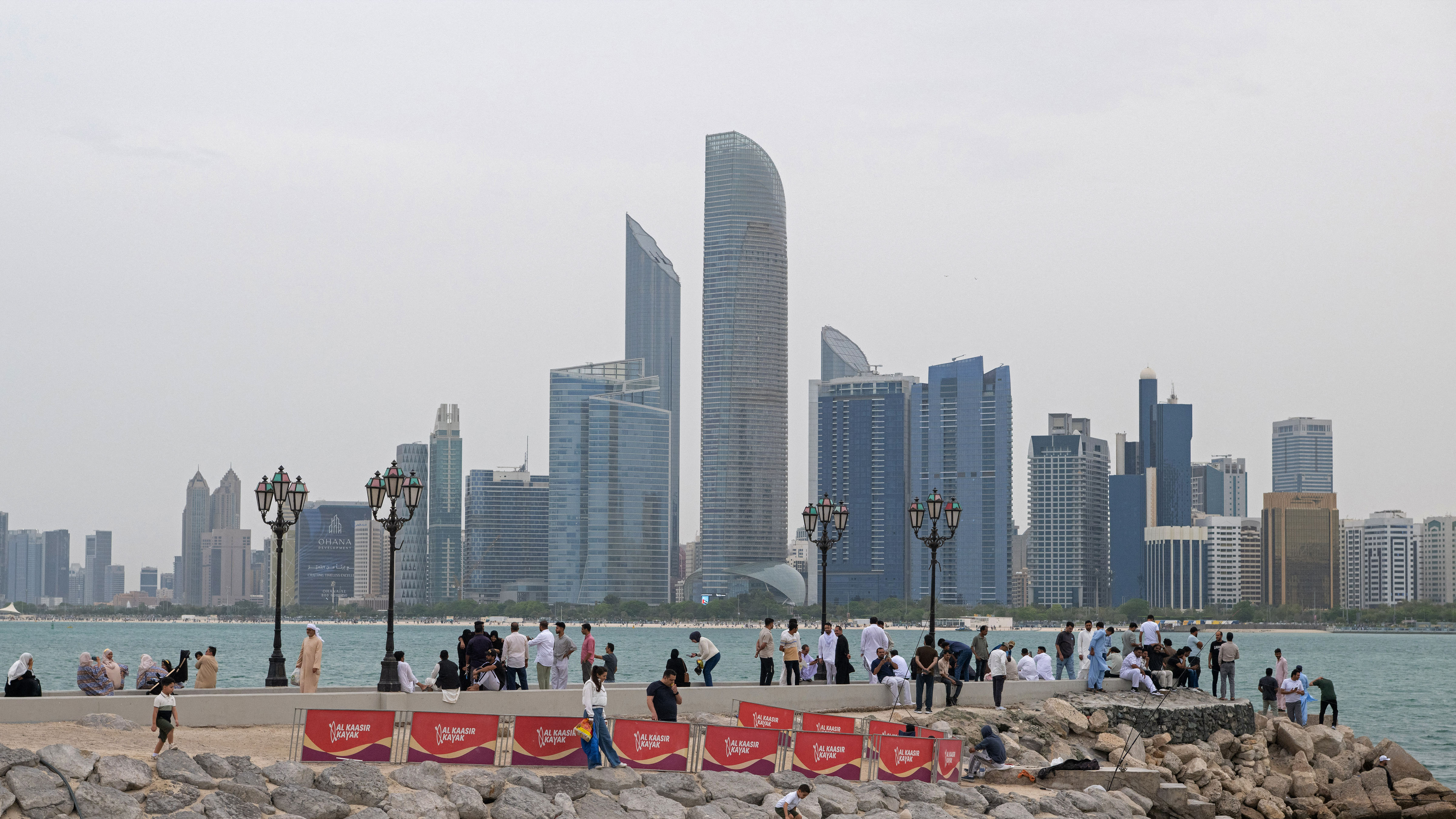 People sit along the corniche area on the occasion of Eid al-Fitr, marking the end of the holy month of Ramadan, in Abu Dhabi on March 20, 2026.