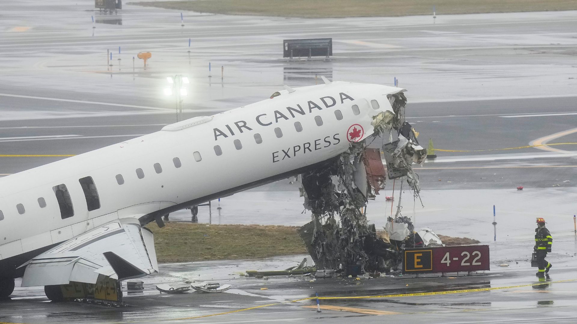 A firefighter walks the site where an Air Canada jet came to rest after colliding with a Port Authority fire truck at LaGuardia Airport, after landing Sunday night in New York.