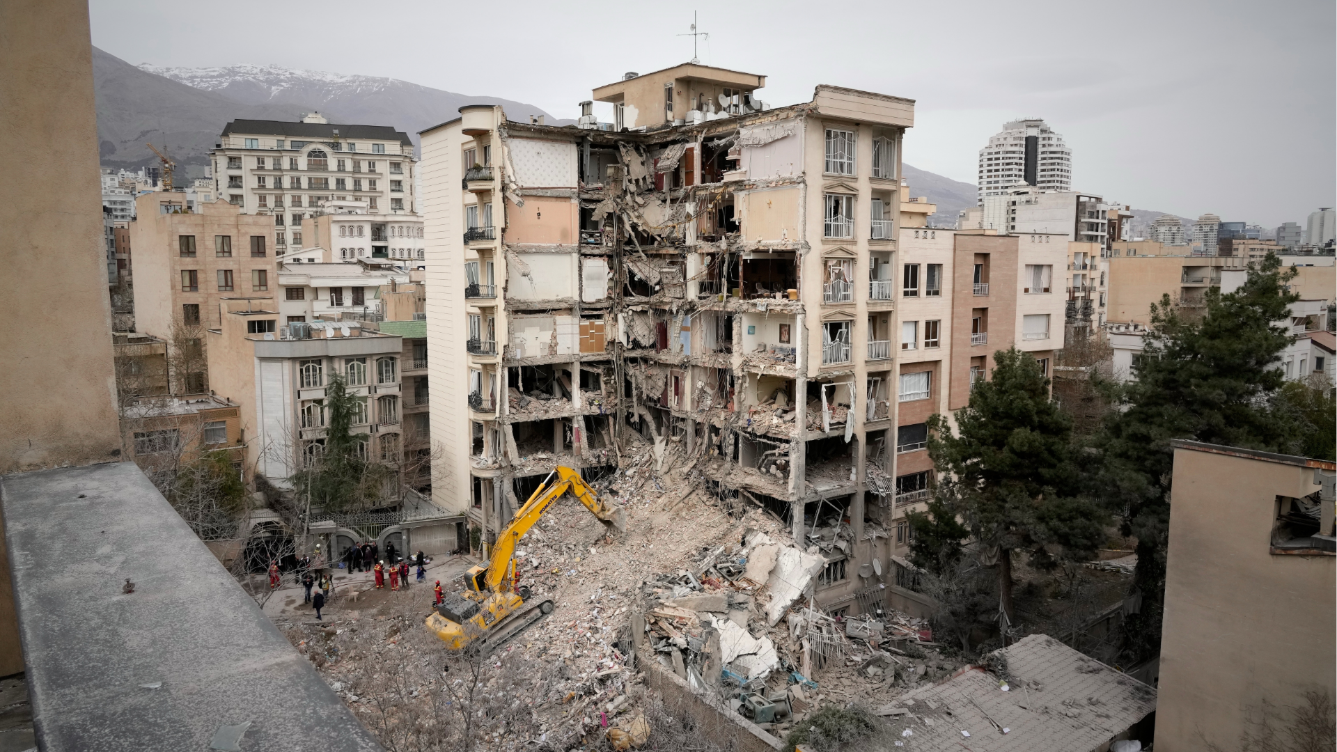 Iranian Red Crescent emergency workers use a bulldozer to clear rubble from a residential building that was hit in an U.S.-Israeli strike in Tehran, Iran, Monday, March 23, 2026.