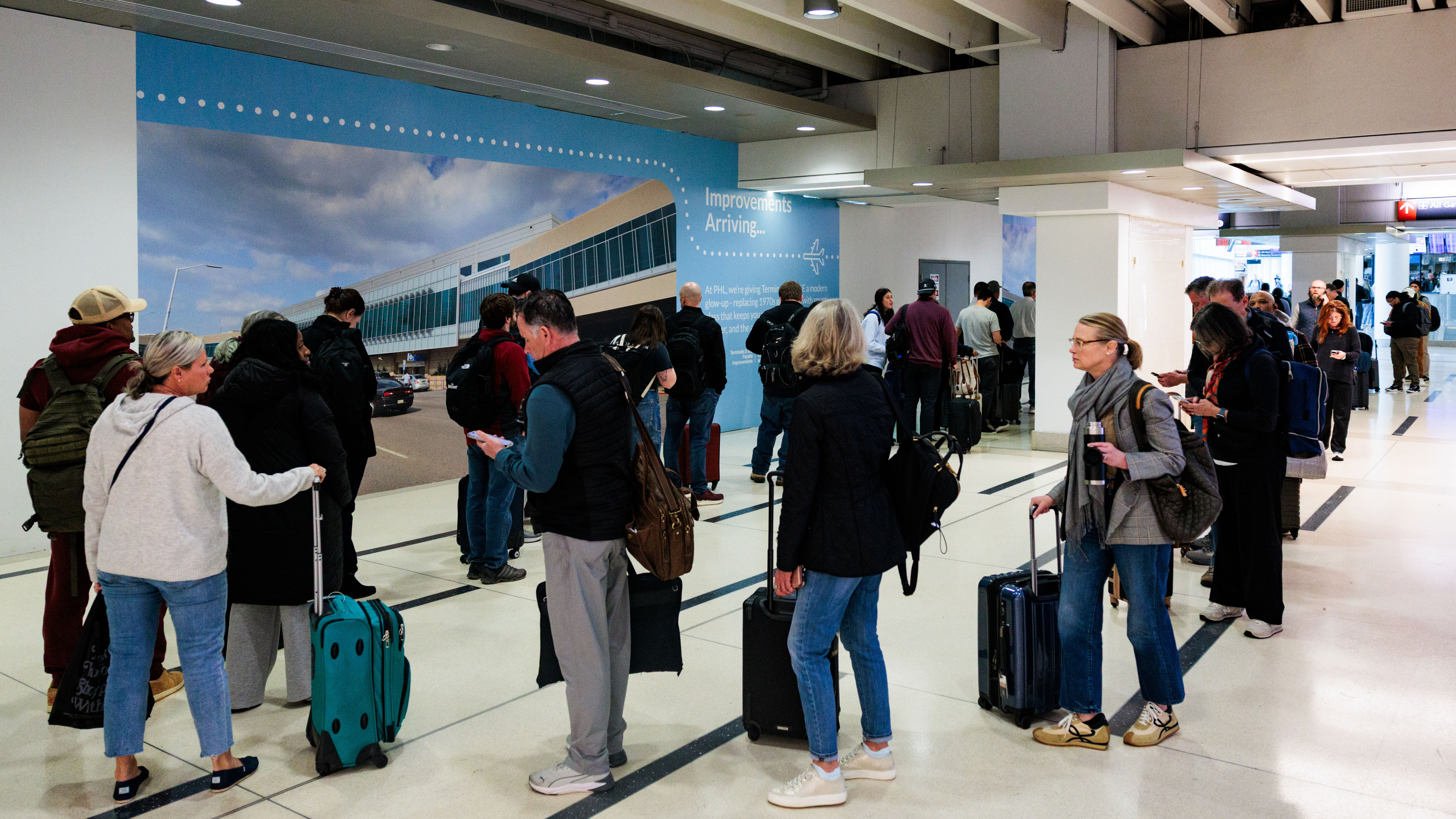 People wait in a TSA line at Philadelphia International Airport, Monday, March 23, 2026, in Philadelphia.