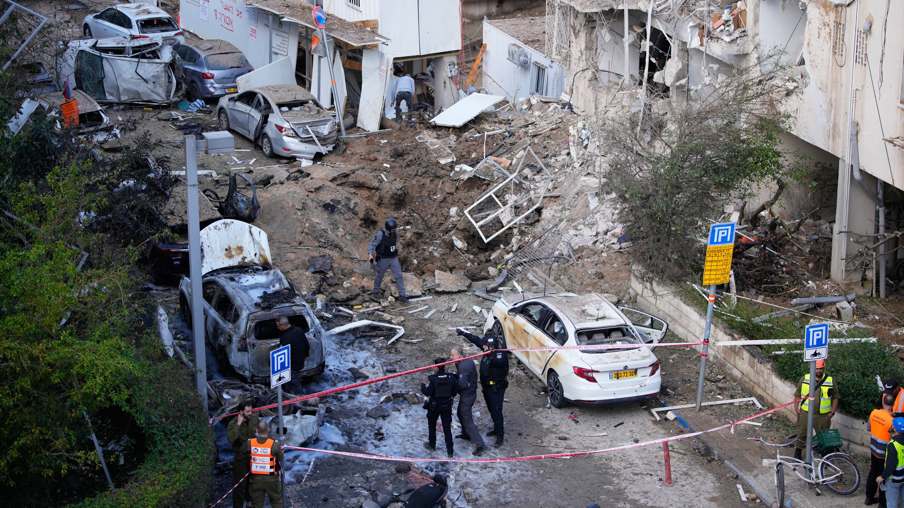 Equipos de rescatistas y seguridad trabajan en el lugar de un misil iraní en Tel Aviv, Israel, el martes 24 de marzo de 2026. (AP Foto/Ohad Zwigenberg)
