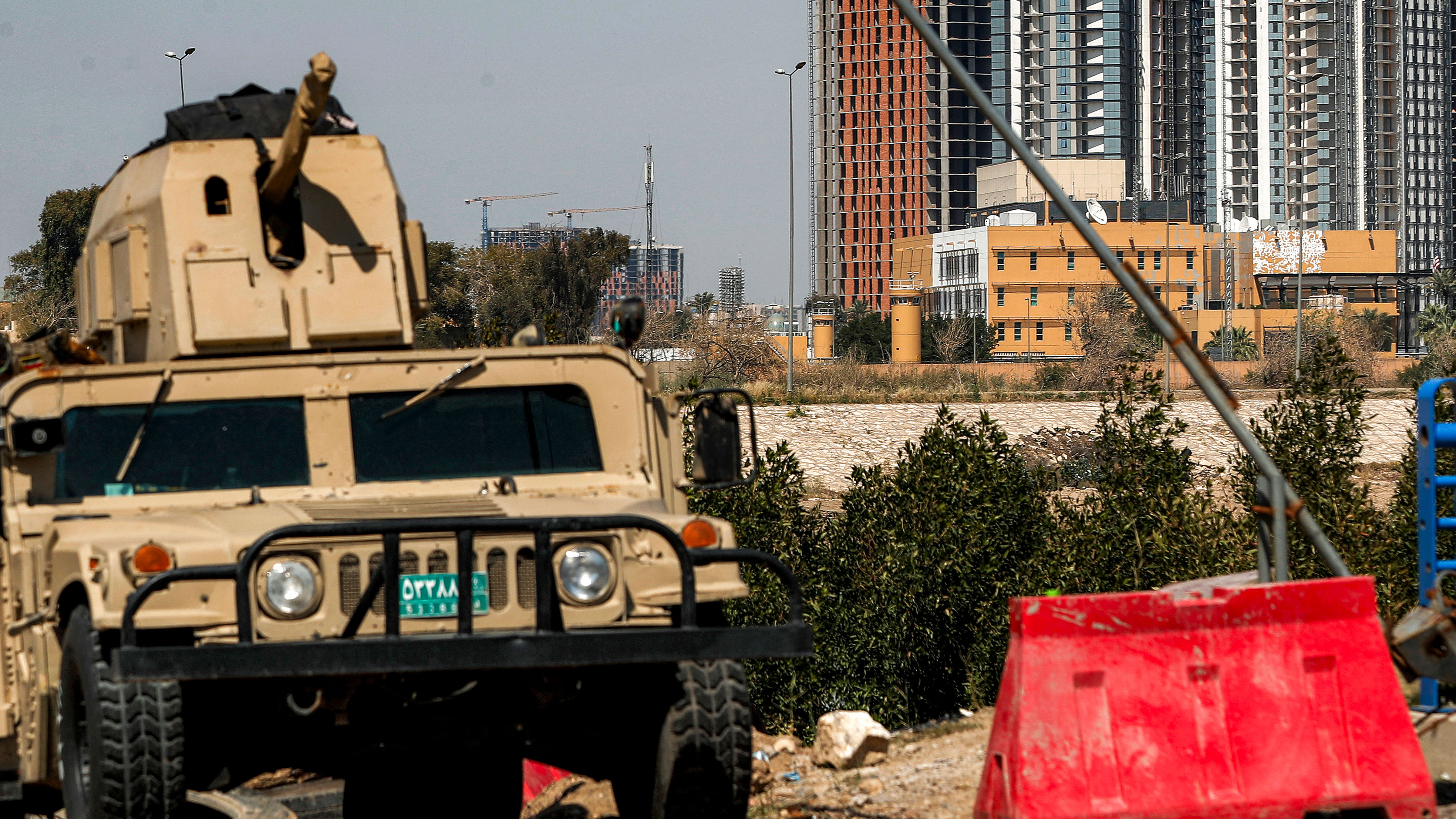 An Iraqi army armoured humvee vehicle is deployed to protect the US Embassy headquarters (R) in Baghdad's fortified "Green Zone" on March 18, 2026.