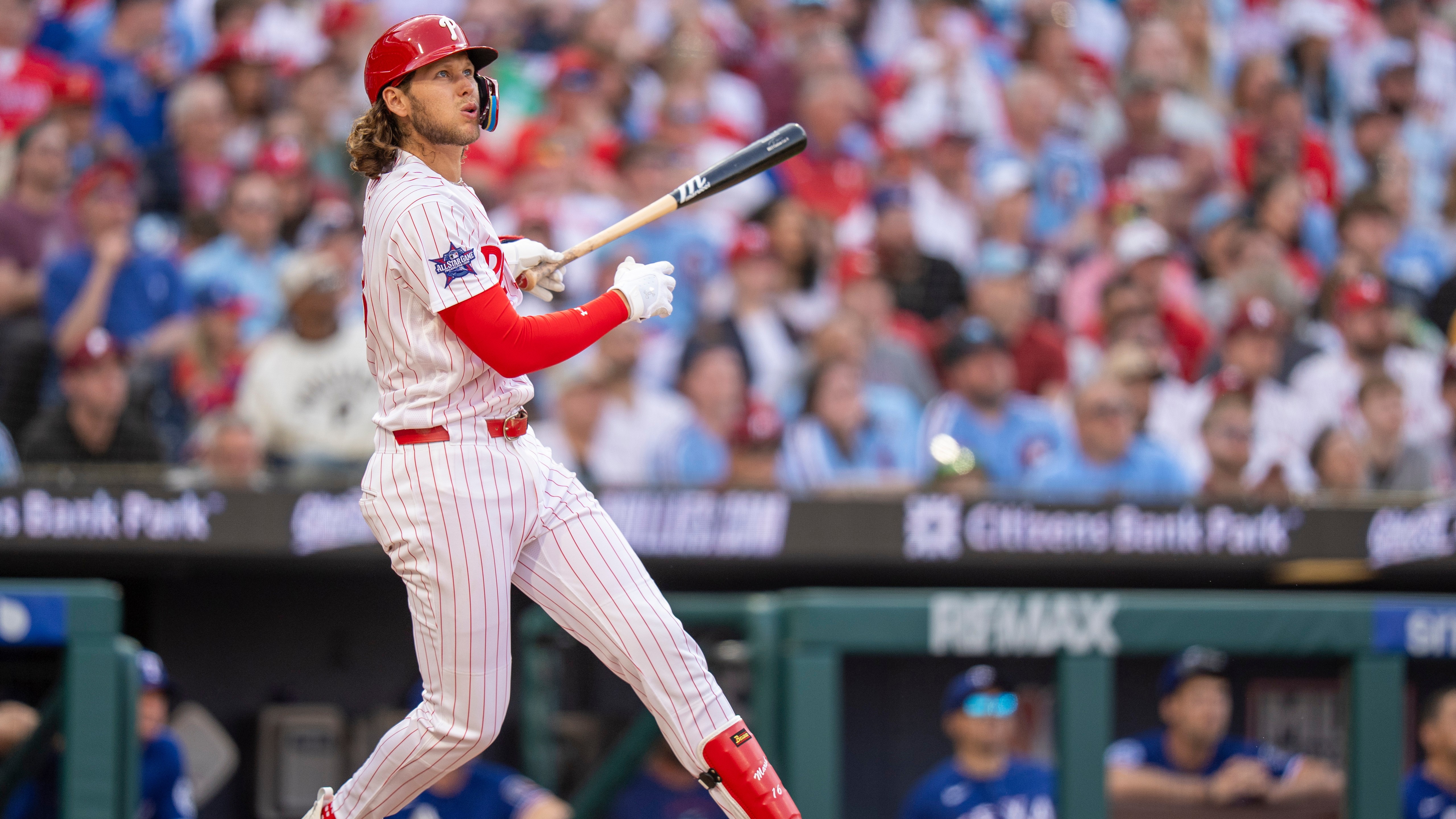 Philadelphia Phillies' Alec Bohm hits a three-run home rum during the fifth inning of an opening-day baseball game against the Texas Rangers.