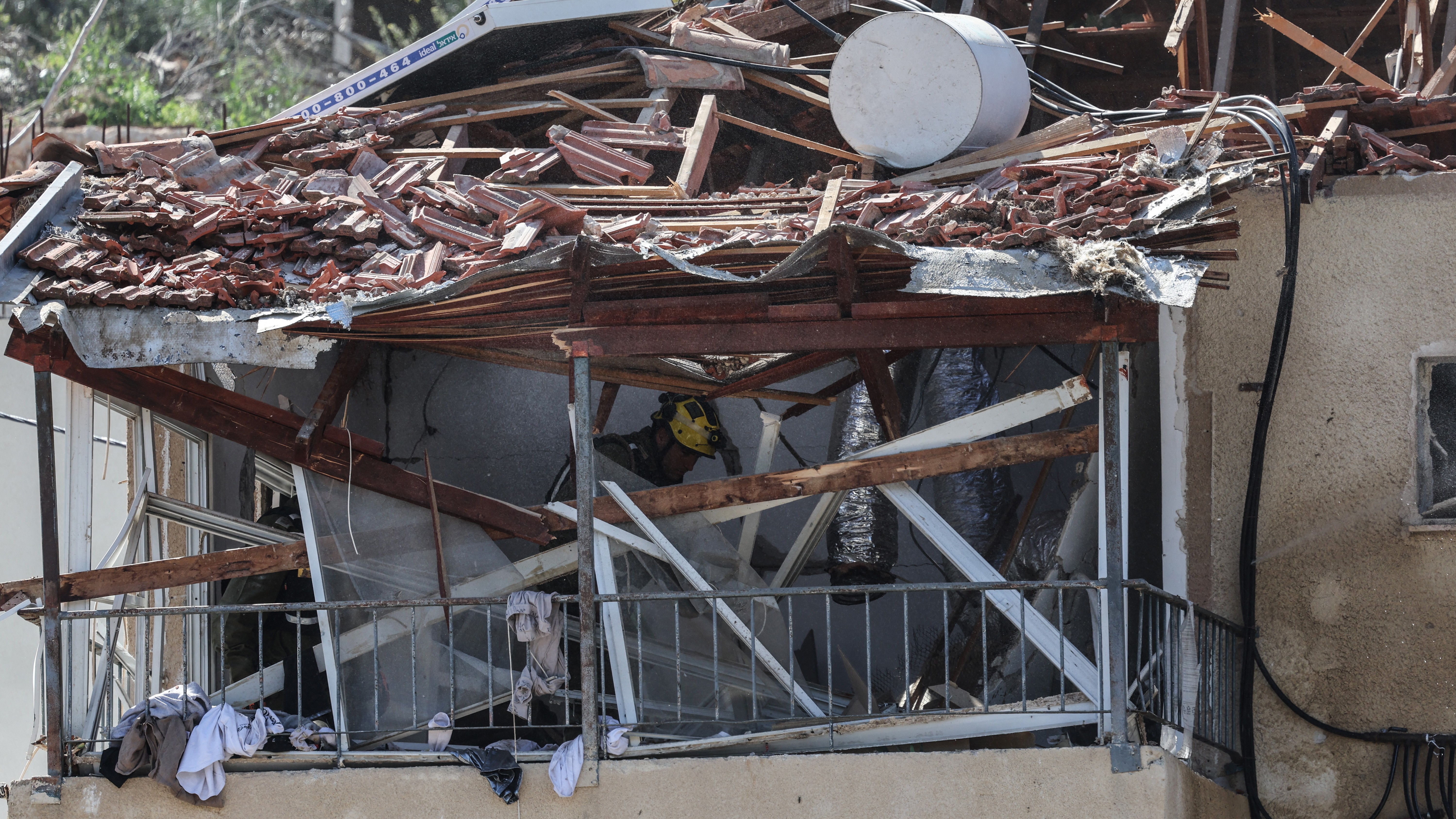 A first responder works at the site of a projectile strike that damaged a house in Eshtaol, near Beit Shemesh in central Israel, on March 28, 2026.