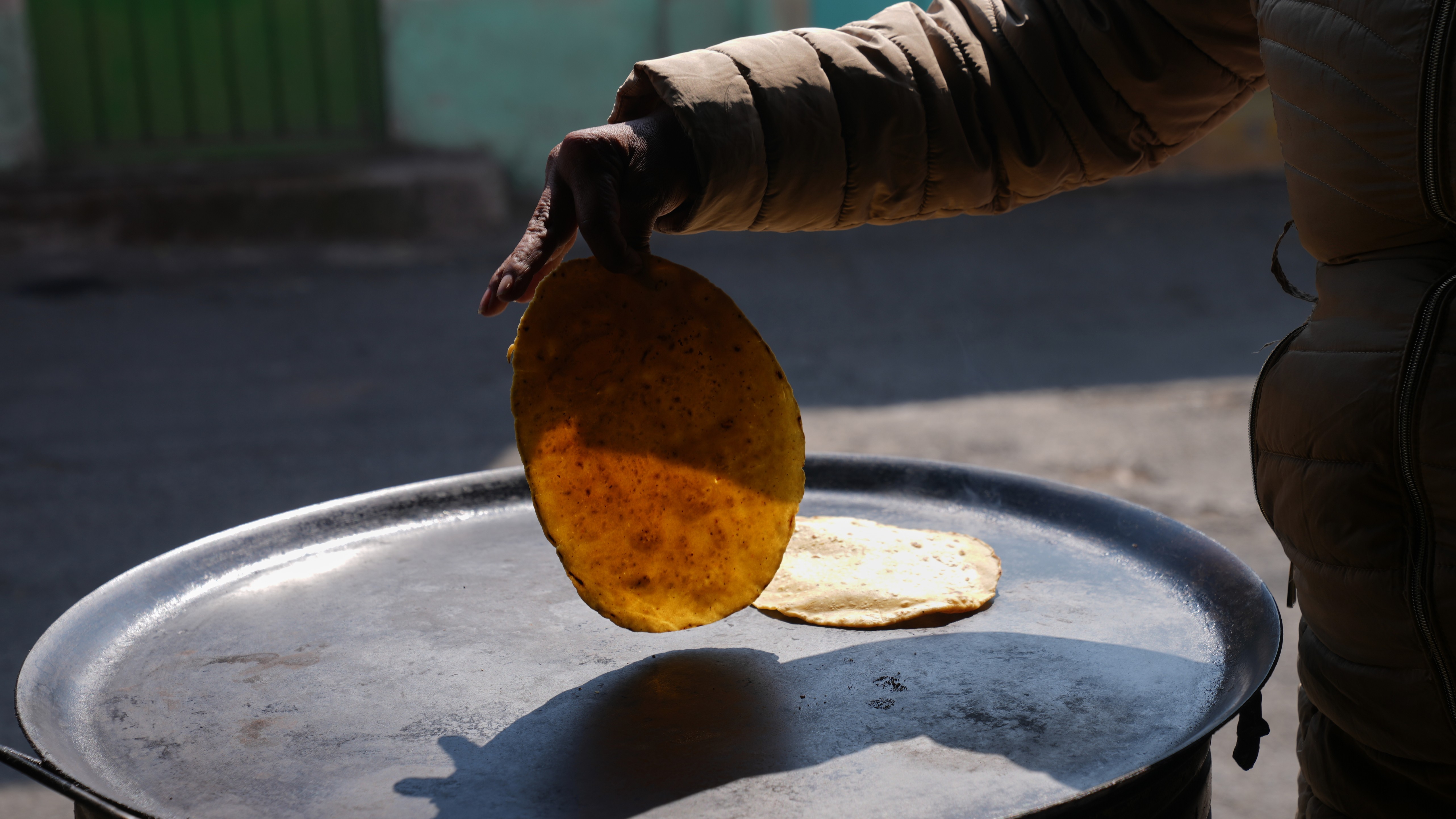 A woman browns tortillas for quesadillas outside her front door in San Antonio Tlaltecahuacan, Mexico, Thursday, Feb. 5, 2026.
