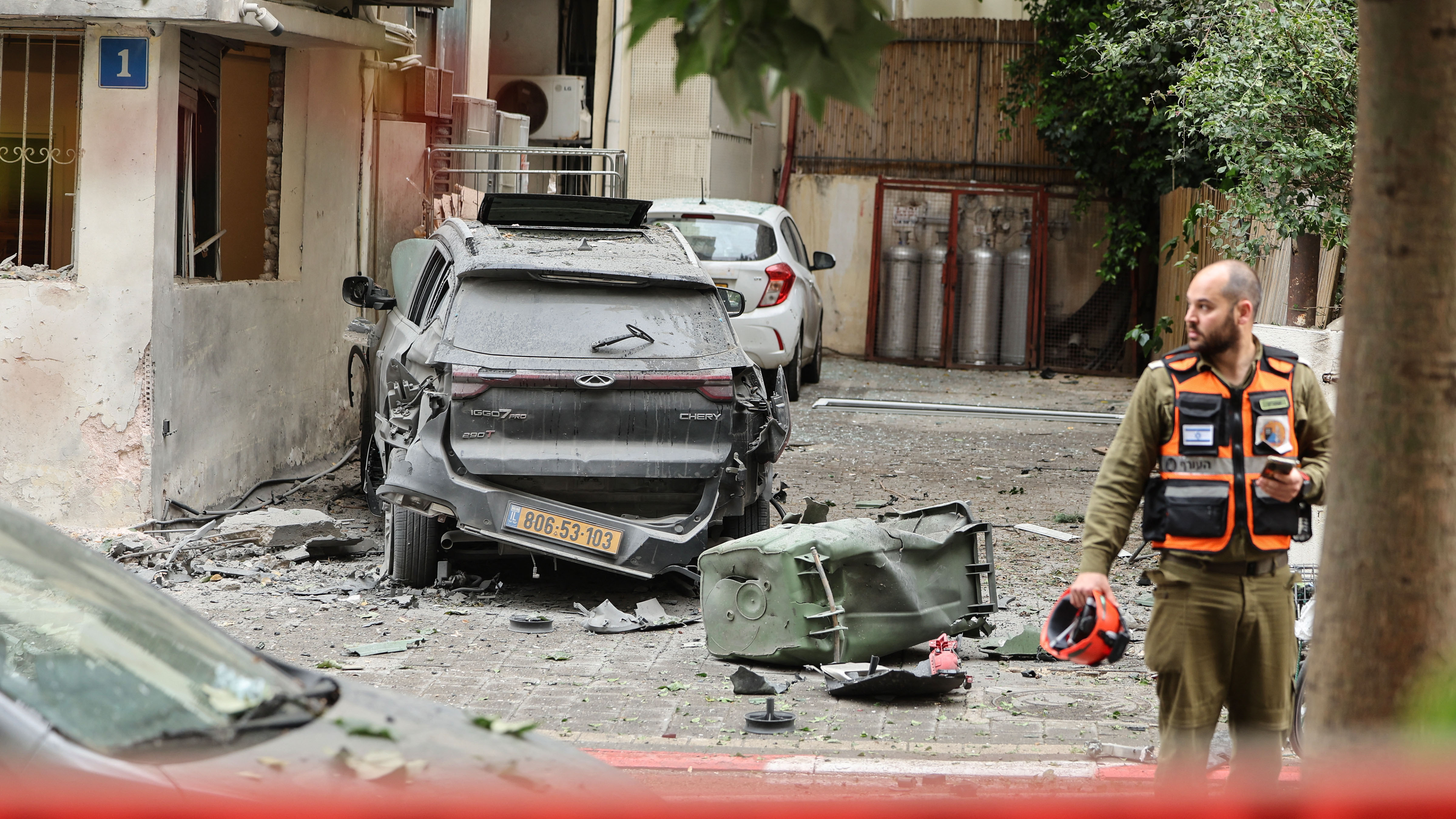 A first responder stands at the site of an impact in a residential neighborhood of Tel Aviv following an Iranian strike, on April 1, 2026.