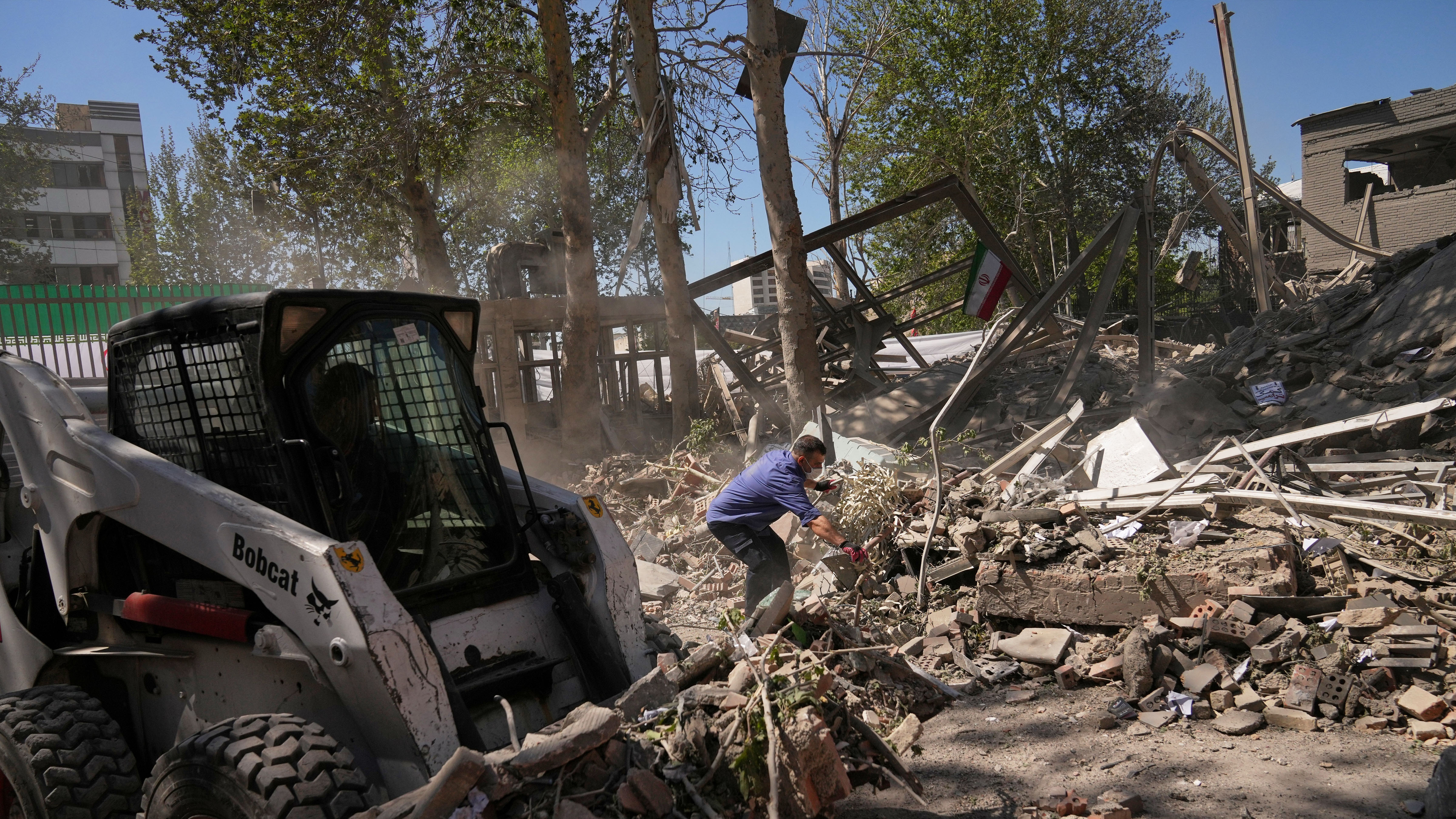 Workers remove debris at Tehran's Sharif University of Technology complex that Iranian authorities say was hit early Monday, April 6, 2026.