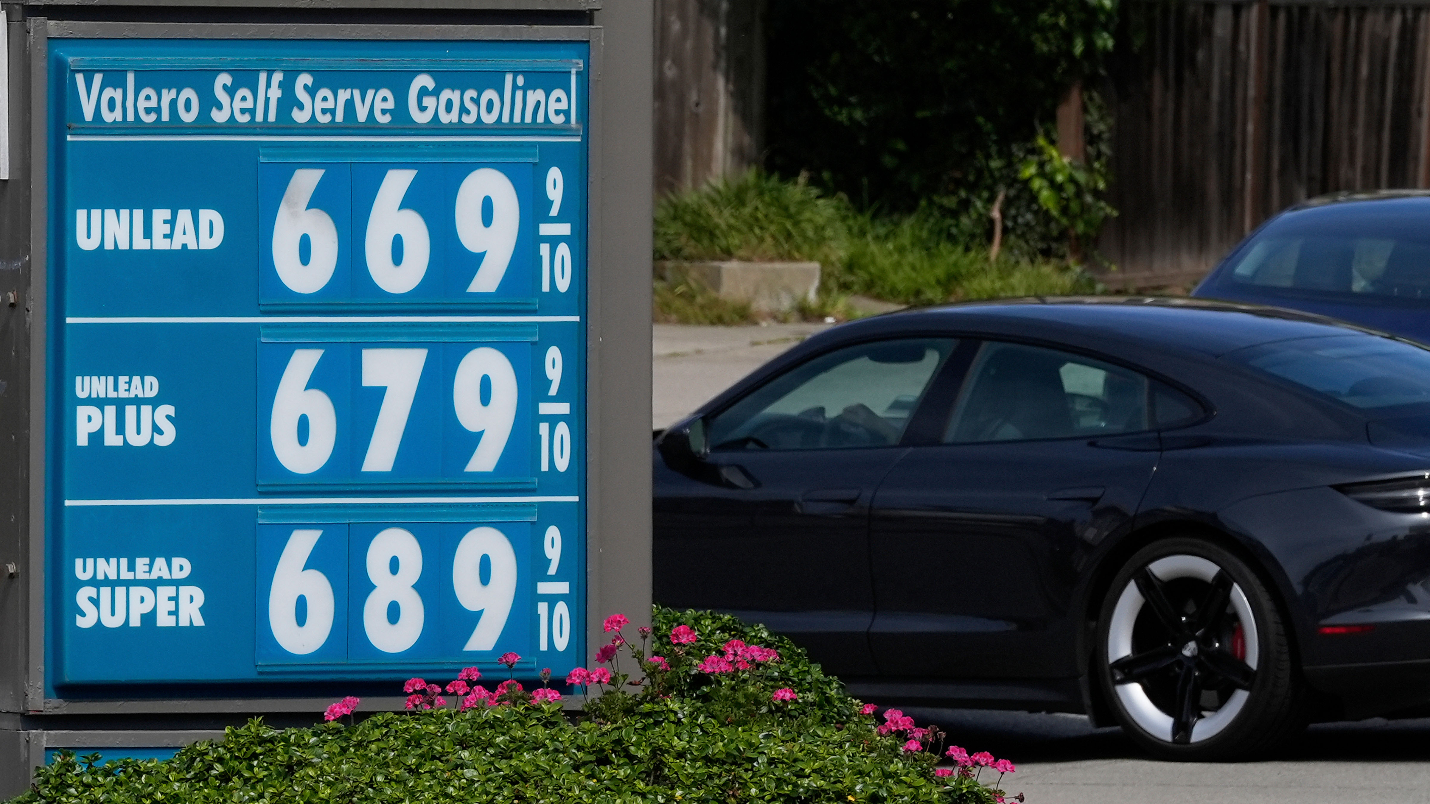 A car drives behind the gasoline price board at a Valero gas station in San Francisco, Saturday, April 4, 2026.