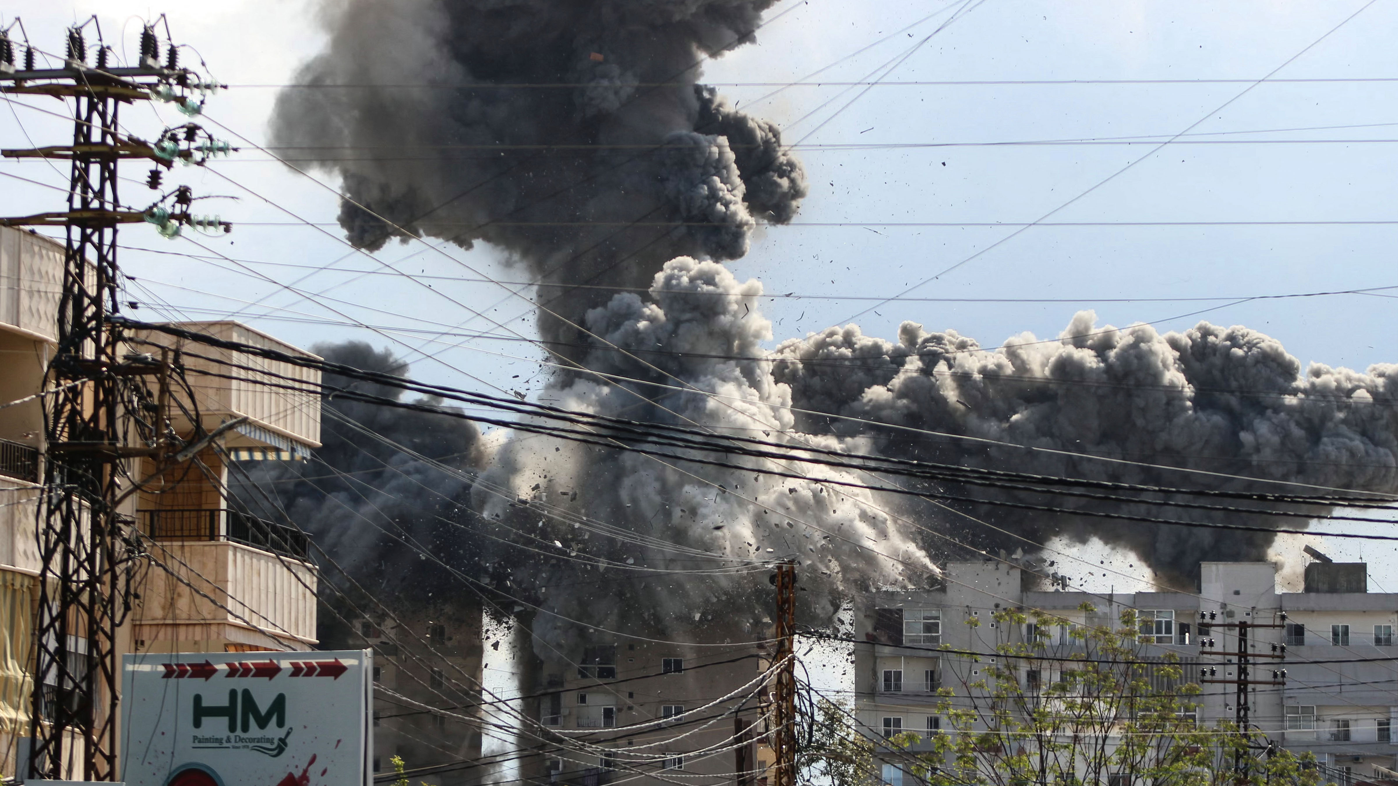 Smoke and debris rise after a building is hit by an Israeli airstrike in the area of Abbasiyeh, on the outskirts of the southern Lebanese city of Tyre, on April 8, 2026.