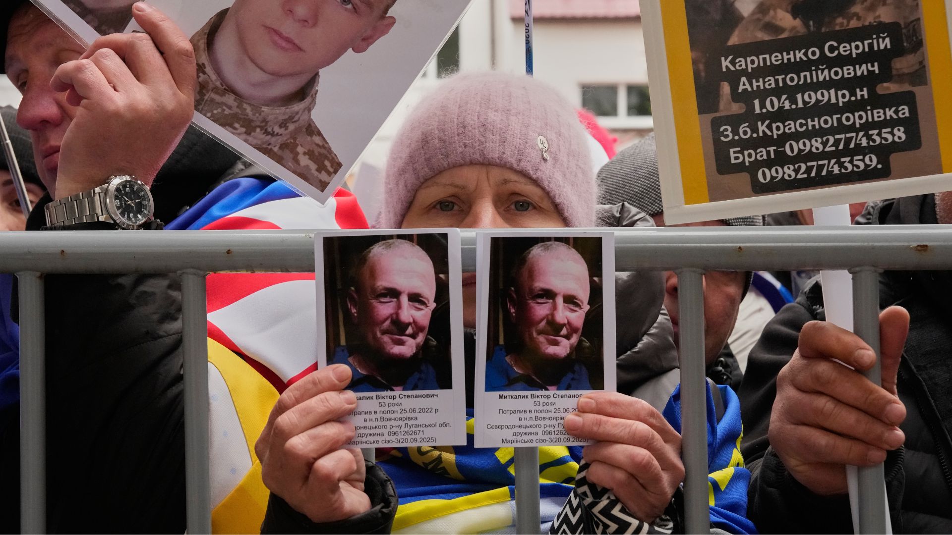 People hold photos of missed relatives as Ukrainian soldiers return from captivity during a POW exchange between Russia and Ukraine in Chernyhiv region, Saturday, April 11, 2026.