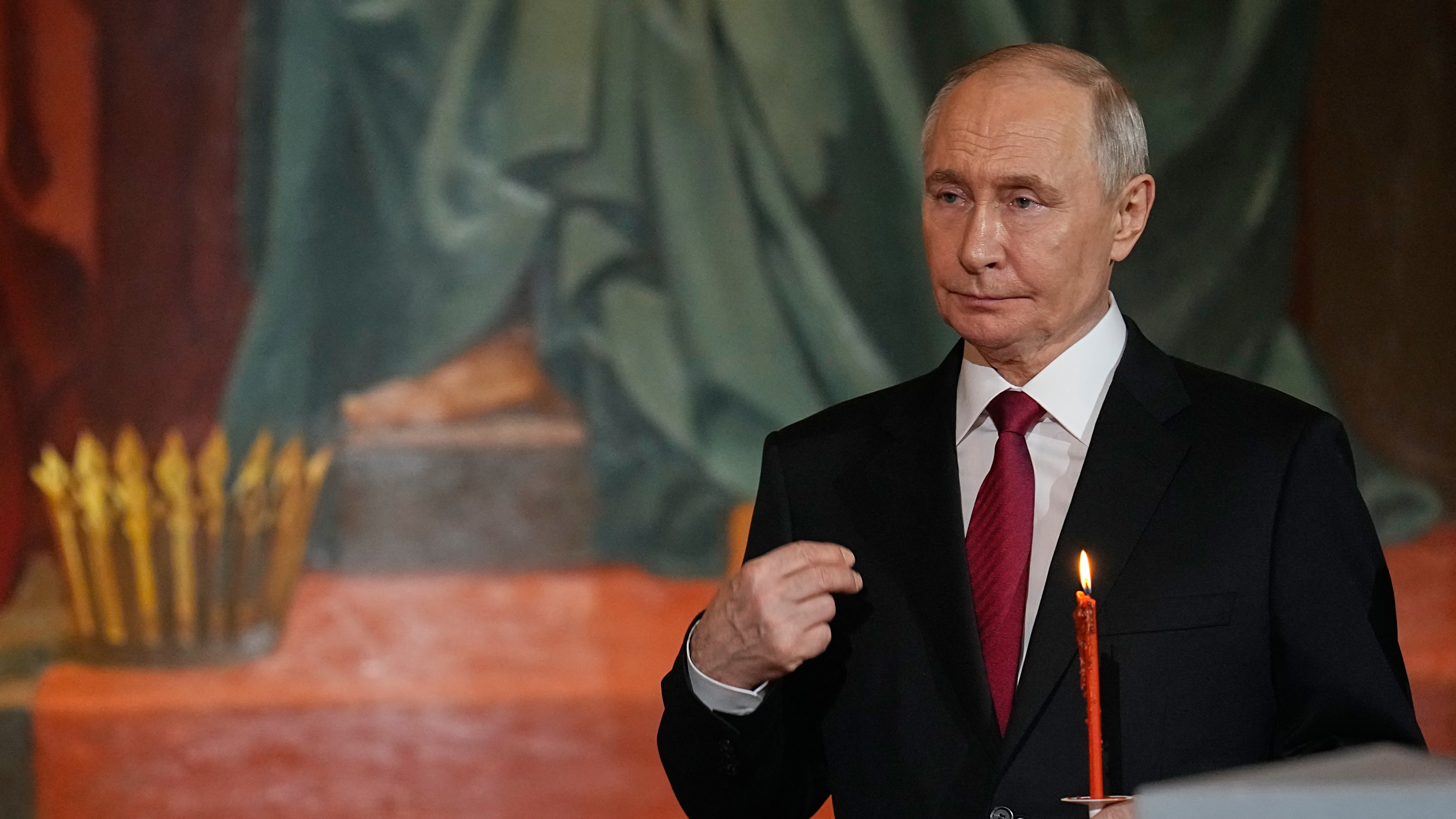 Russia's President Vladimir Putin makes the sign of the cross during the Orthodox Easter service at the Cathedral of Christ the Saviour in Moscow on April 12, 2026.