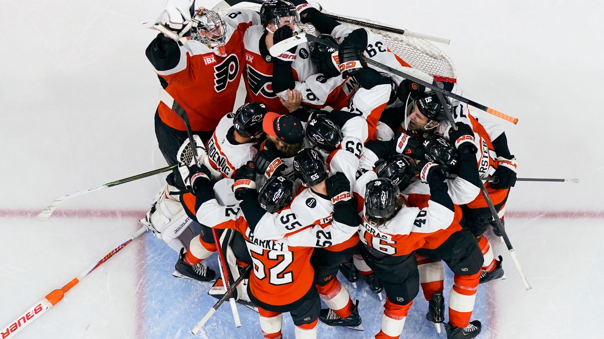 Flyers gather around the net of goalie Dan Vladar, top left, as they celebrate after making the playoffs after an NHL game against the Hurricanes, Monday, April 13, 2026.