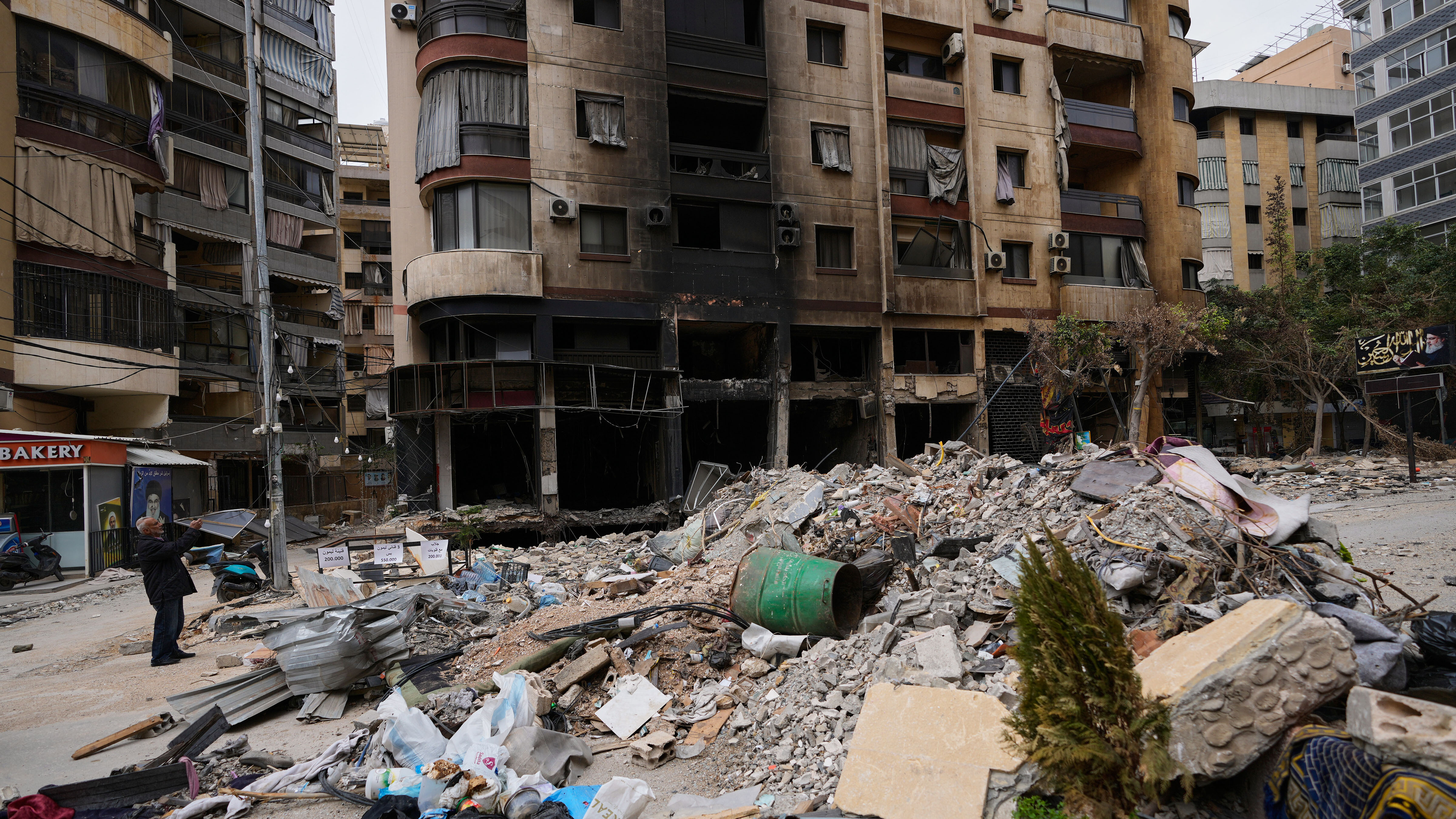 A man takes pictures of a destroyed building following a ceasefire between Hezbollah and Israel, in Dahiyeh, Beirut's southern suburbs, Lebanon, Monday, April 20, 2026.