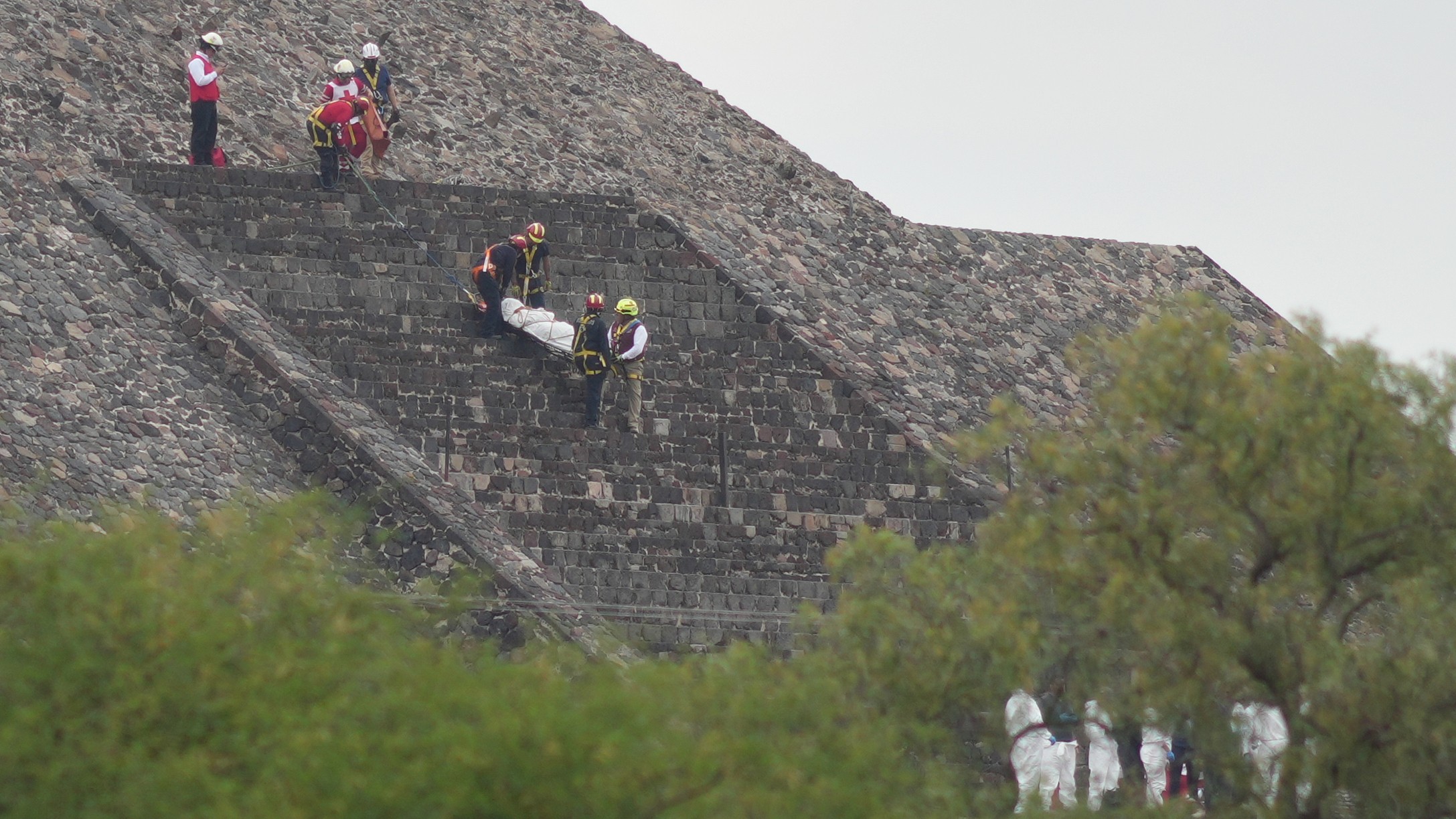 Los forenses bajan el cadáver de una víctima por una pirámide después de que, según las autoridades, un hombre armado abriera fuego en Teotihuacán, México, el 20 de abril de 2026.