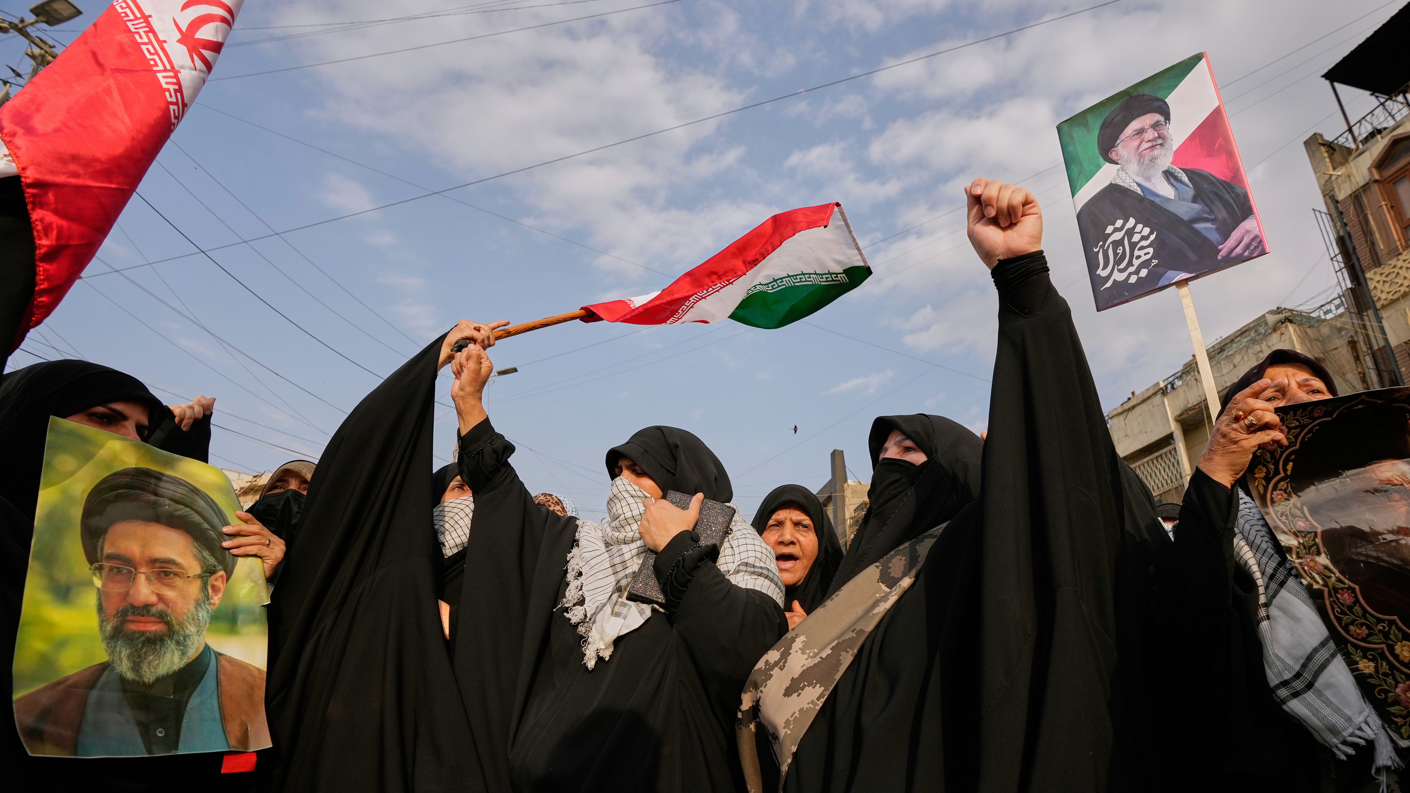 Iraqi Muslim women hold portraits of Iran's late Supreme Leader Ayatollah Ali Khamenei and his son Ayatollah Mojtaba Khamenei, during a protest against U.S. and Israeli attacks.