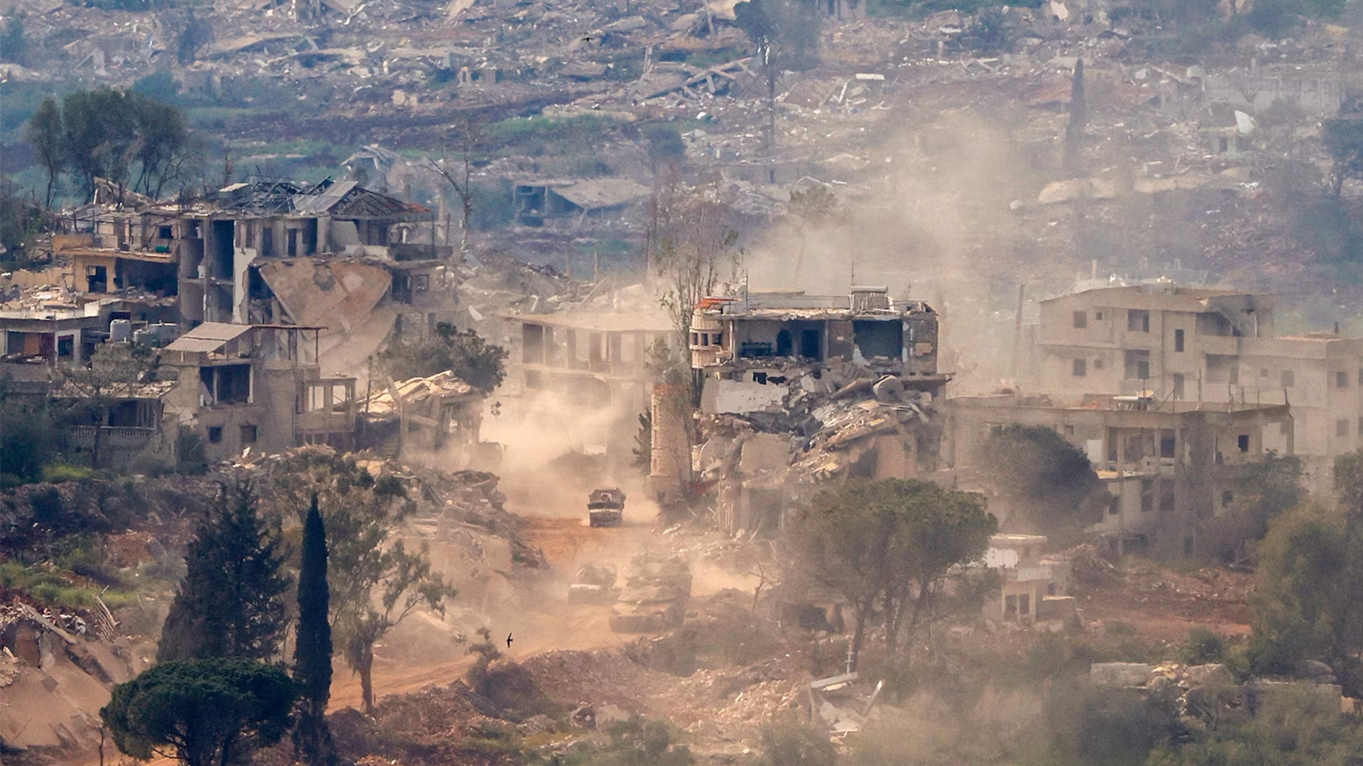 Israeli tanks and military vehicles drive along the road between destroyed houses in southern Lebanon near the border with Israel, on April 25, 2026.