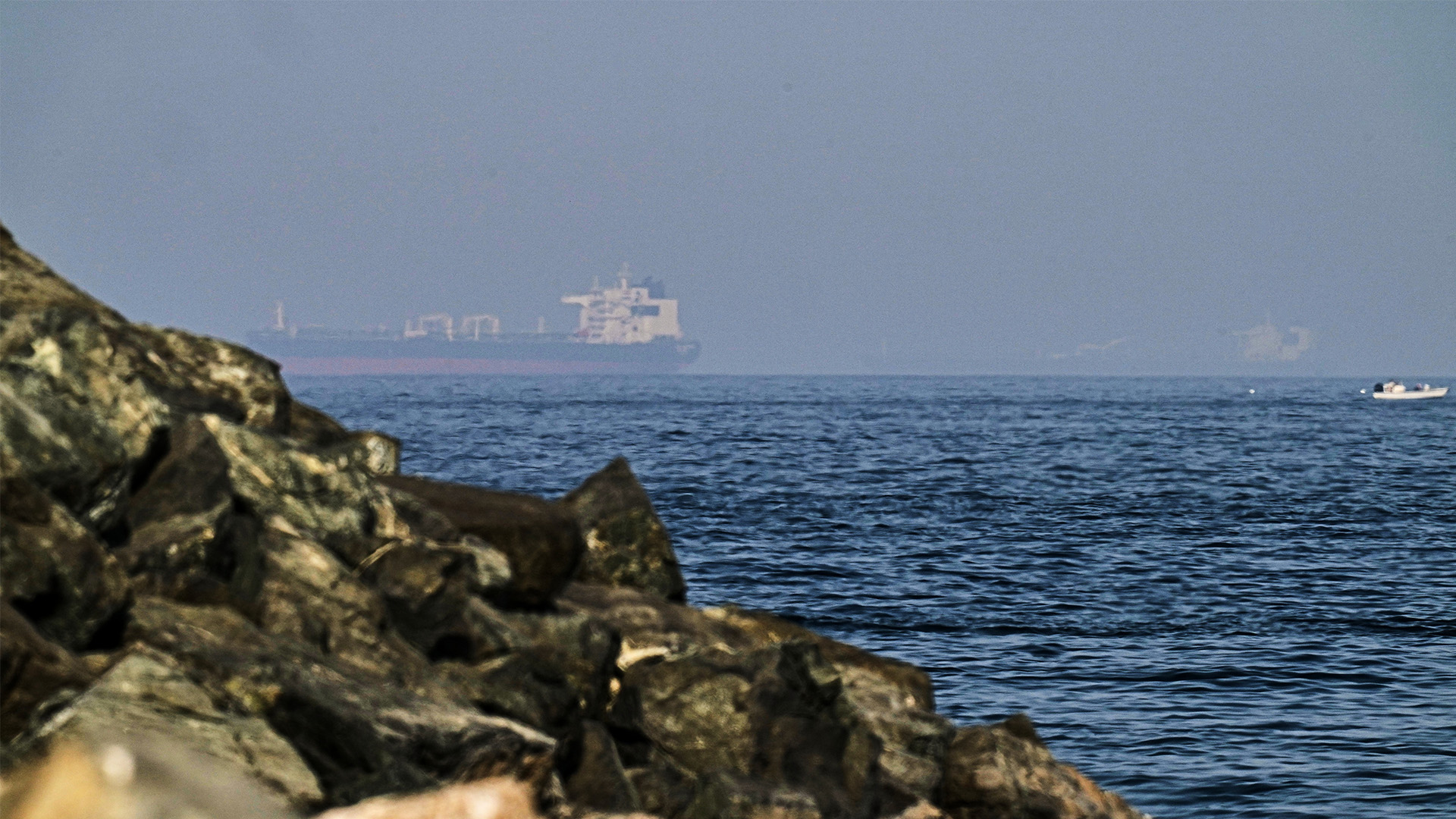 Cargo ships are seen at sea in the Gulf of Oman near the Strait of Hormuz, as viewed from a rocky shoreline near Khor Fakkan, United Arab Emirates, Friday, May 1, 2026.