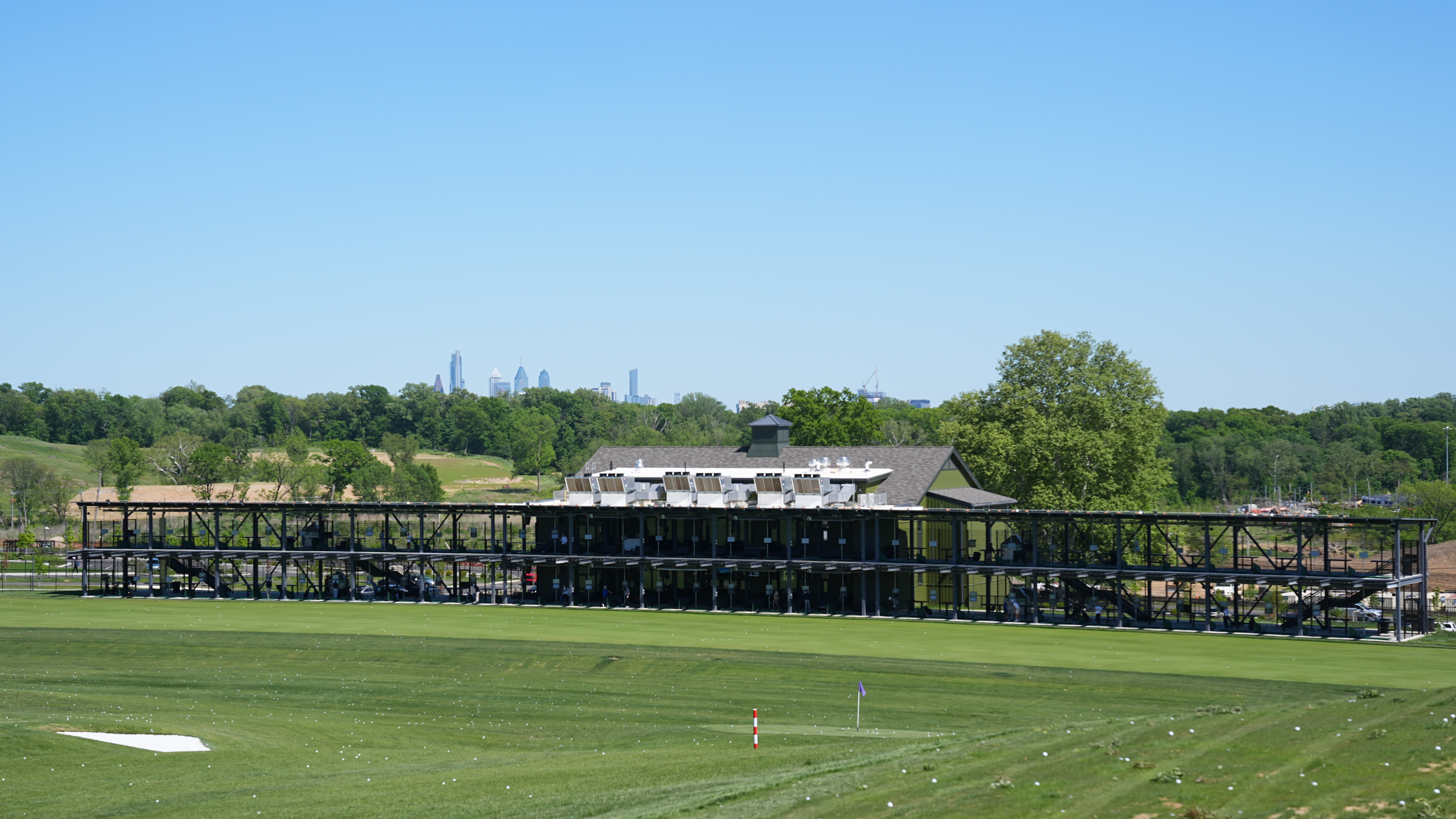 The Philadelphia skyline is seen above the driving range at the Cobbs Creek Golf Club in Philadelphia, Tuesday, May 12, 2026.