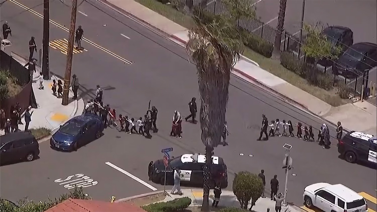 People are led away by police from the Islamic Center of San Diego, May 18, 2026.