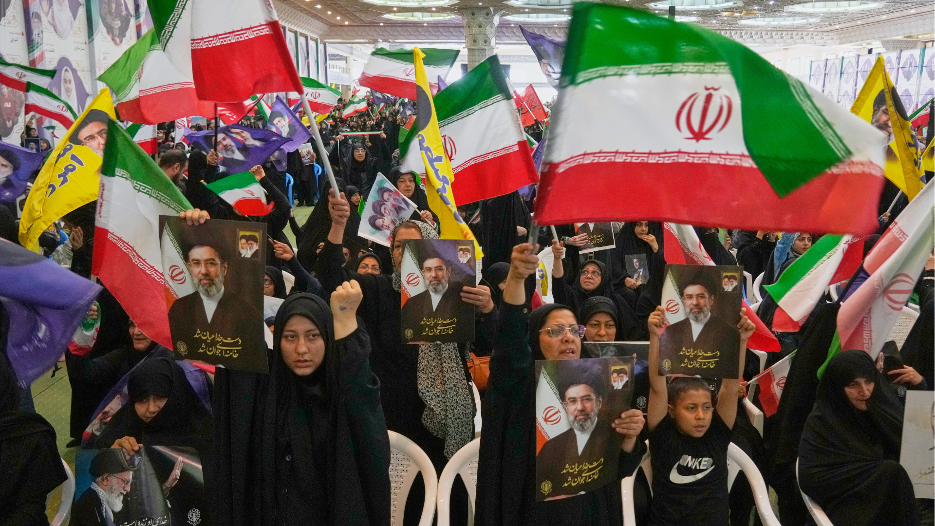 Government supporters hold Iranian flags and pictures of Iran's Supreme Leader, Ayatollah Mojtaba Khamenei, at the Imam Khomeini Grand Mosque in Tehran, Iran, Sunday, May 24, 2026.