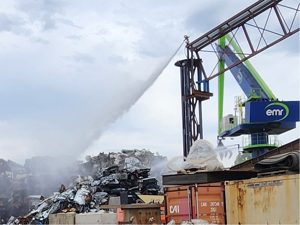 Photo shows EMR fire surpressor system with sprayer attached tp blue/green crane arm picker that sorts material