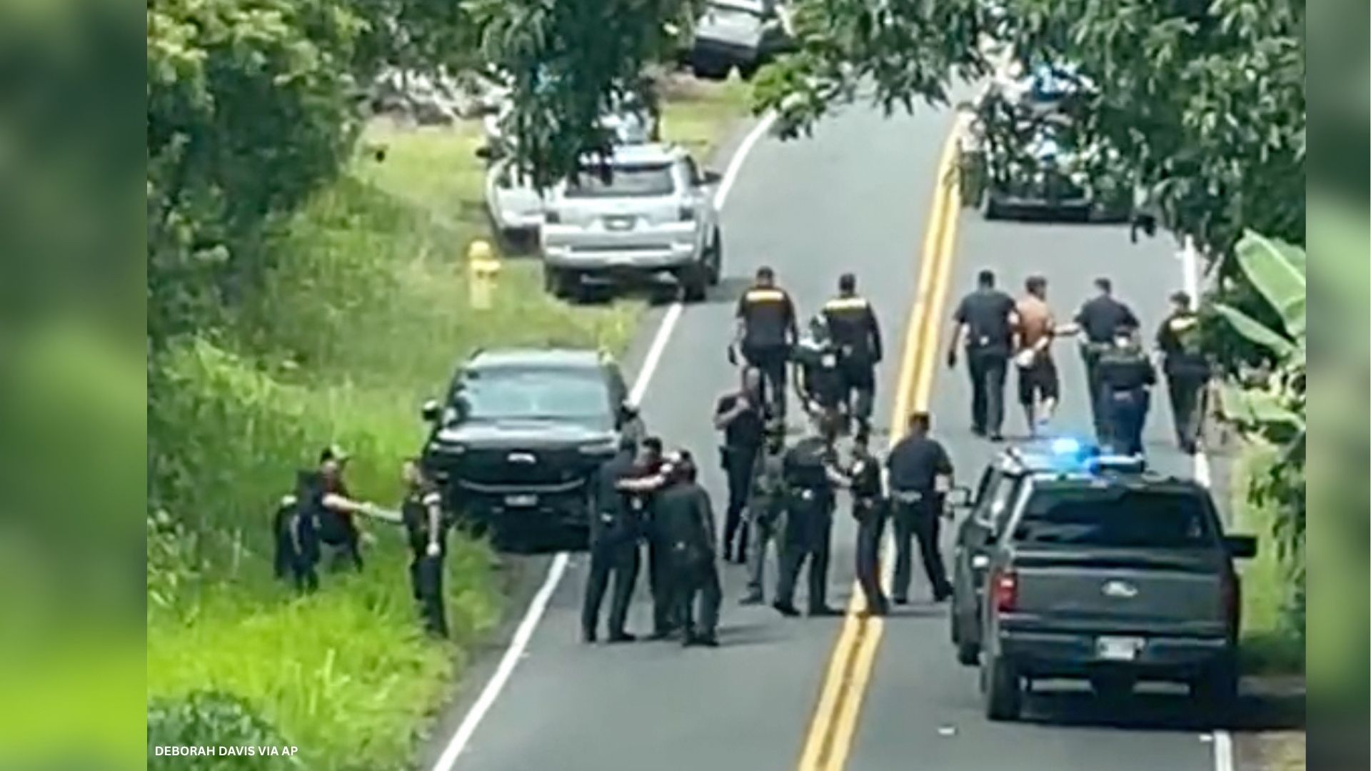 Police arrest a man accused of multiple killings, right, on Thursday, May 28, 2026, in Kaimu, Hawaii.