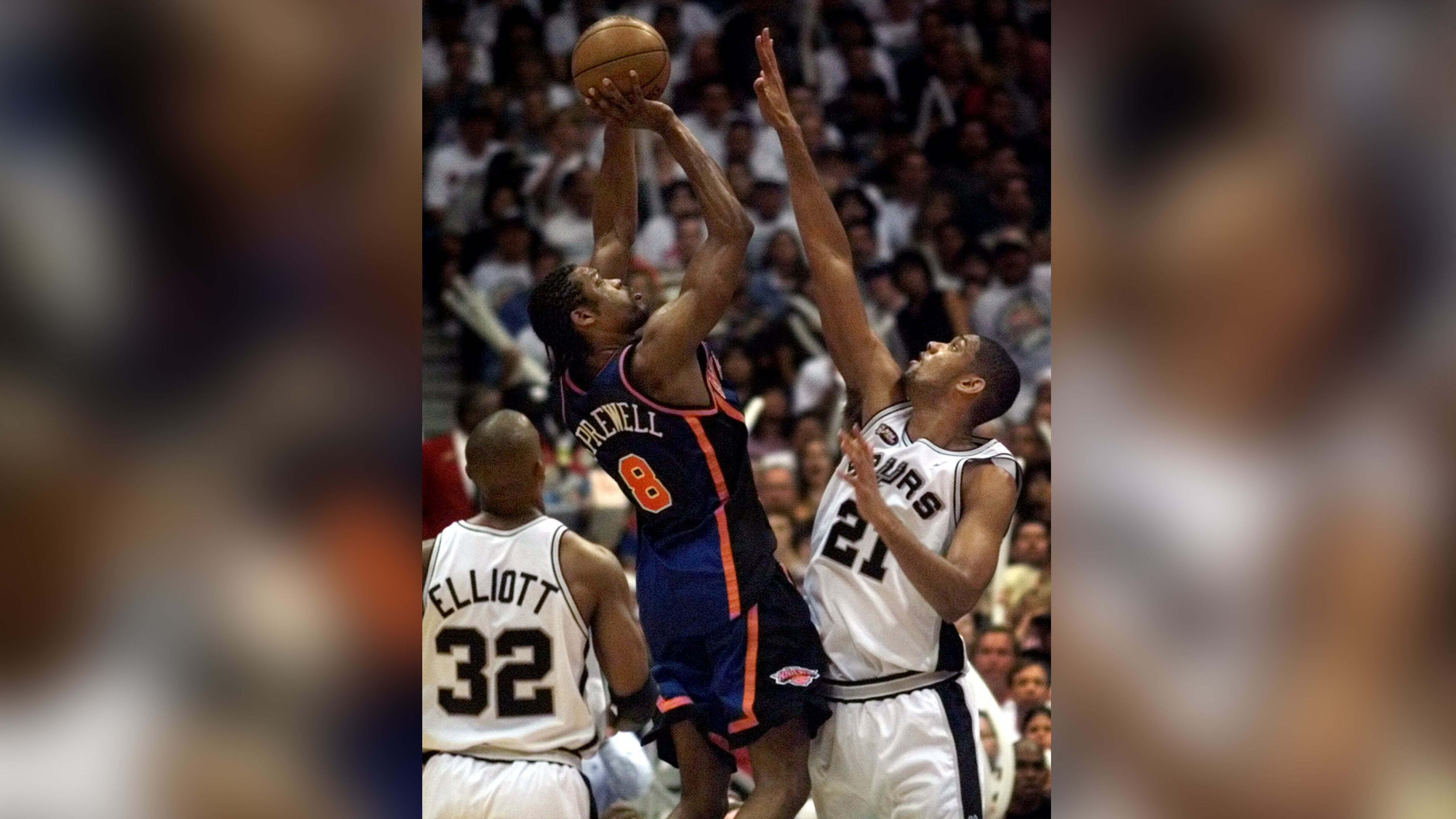 New York Knicks' Latrell Sprewell, center, shoots between San Antonio Spurs' forward Sean Elliott, left, and forward Tim Duncan, in game one of the NBA Finals in San Antonio, Tex., June 16, 1999.