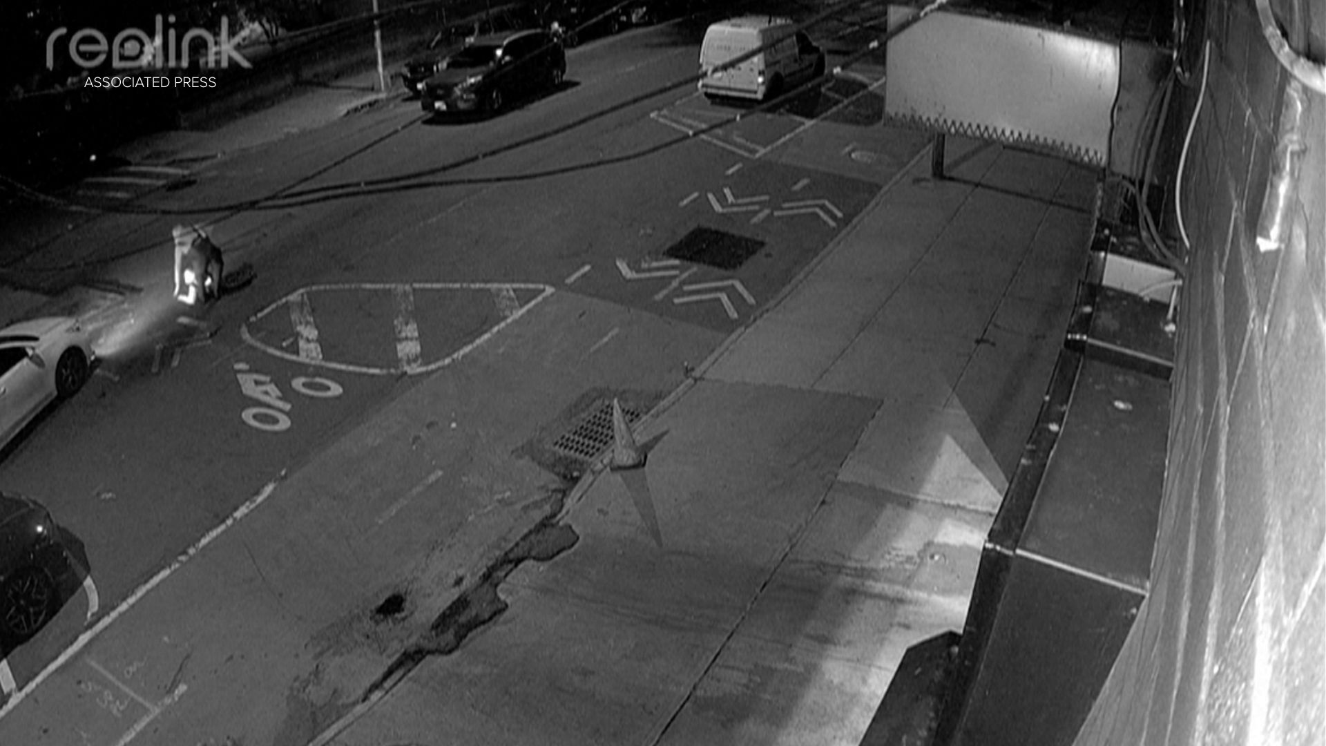 In this image from a surveillance video provided by AKI AUTO CARE, one of three people descends into a sewer on a street in New York, on May 5, 2026. (AKI AUTO CARE via AP)