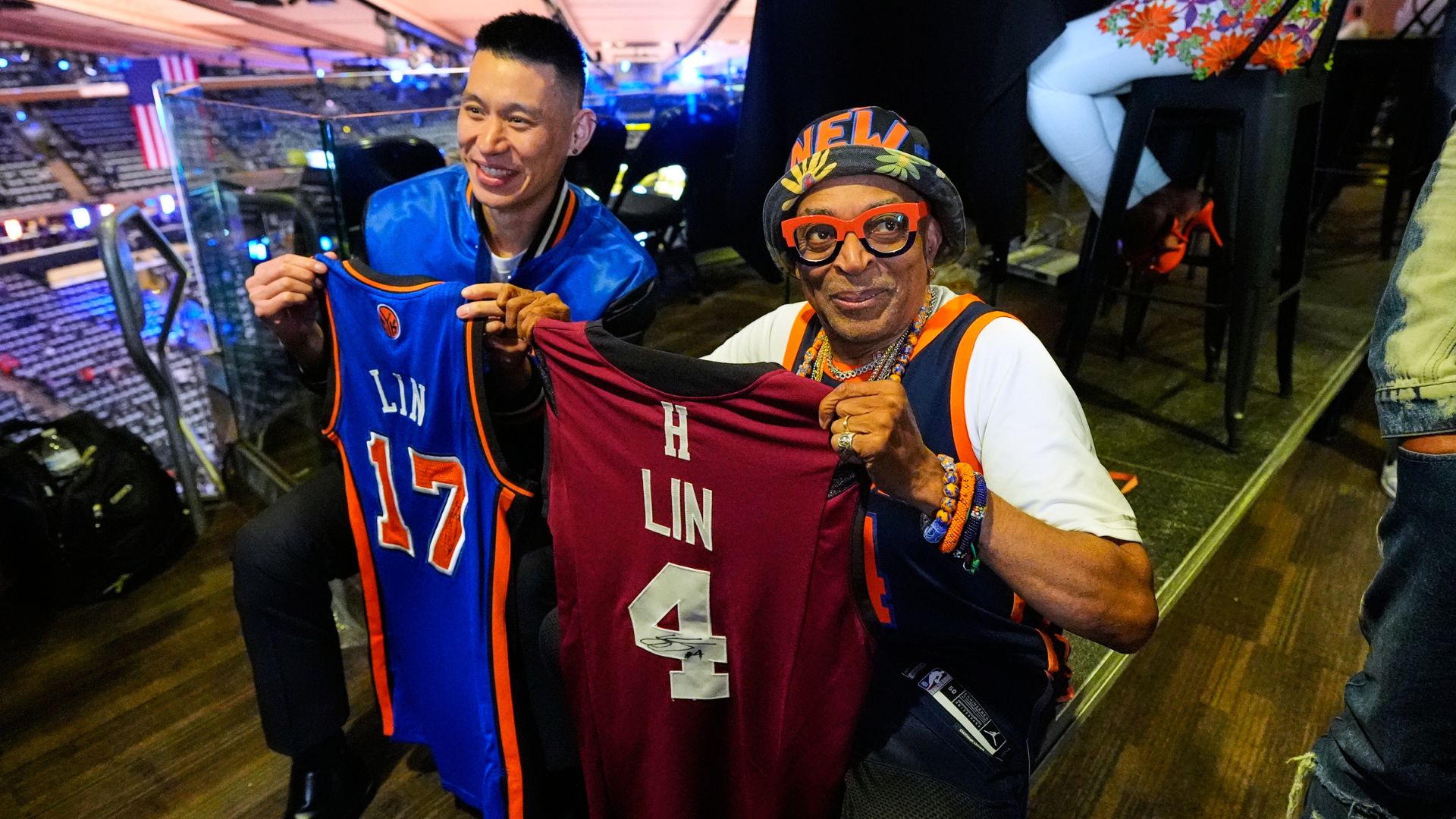 Former NBA player Jeremy Lin, left, and filmmaker Spike Lee hold up jerseys prior to Game 3 in New York. (AP Photo/Yuki Iwamura)