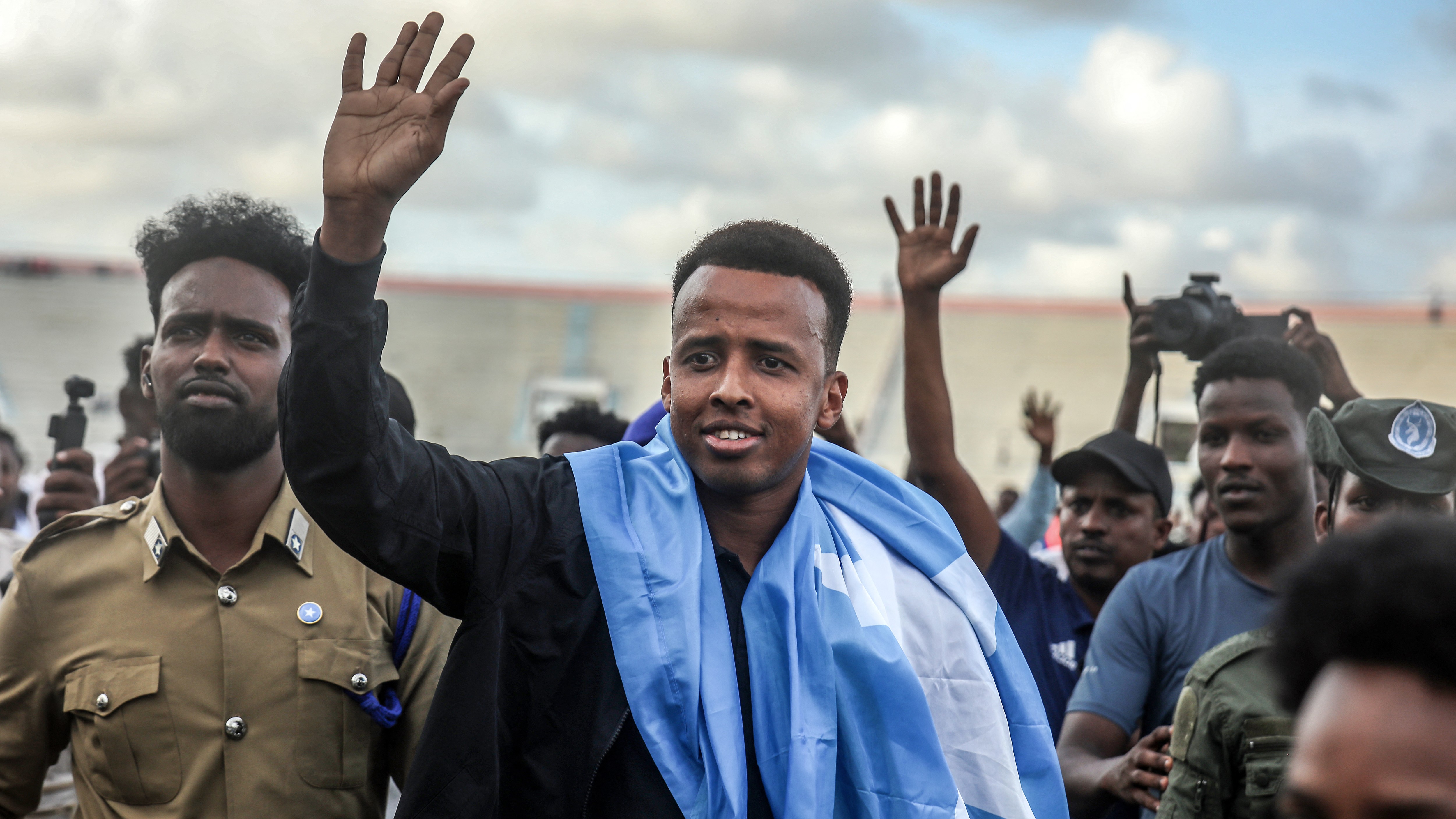 Somali international referee Omar Abdulkadir Artan waves to supporters as he's welcomed ahead of a solidarity football match after returning to Somalia on June 10, 2026.