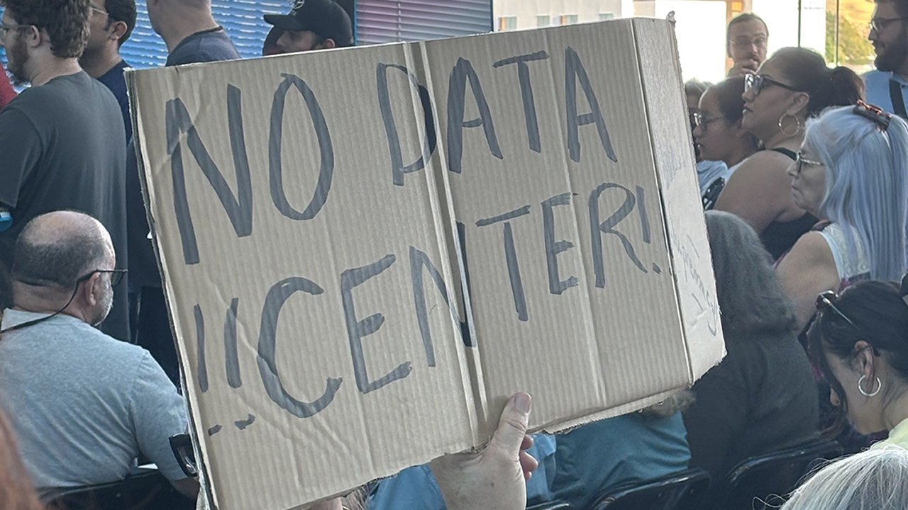 Image obtained by ABC7 Eyewitness News shows a woman holding a "No Data Center" sign at a Pittsburg City Council meeting at Pittsburg, Calif. on Monday, June 15, 2026.