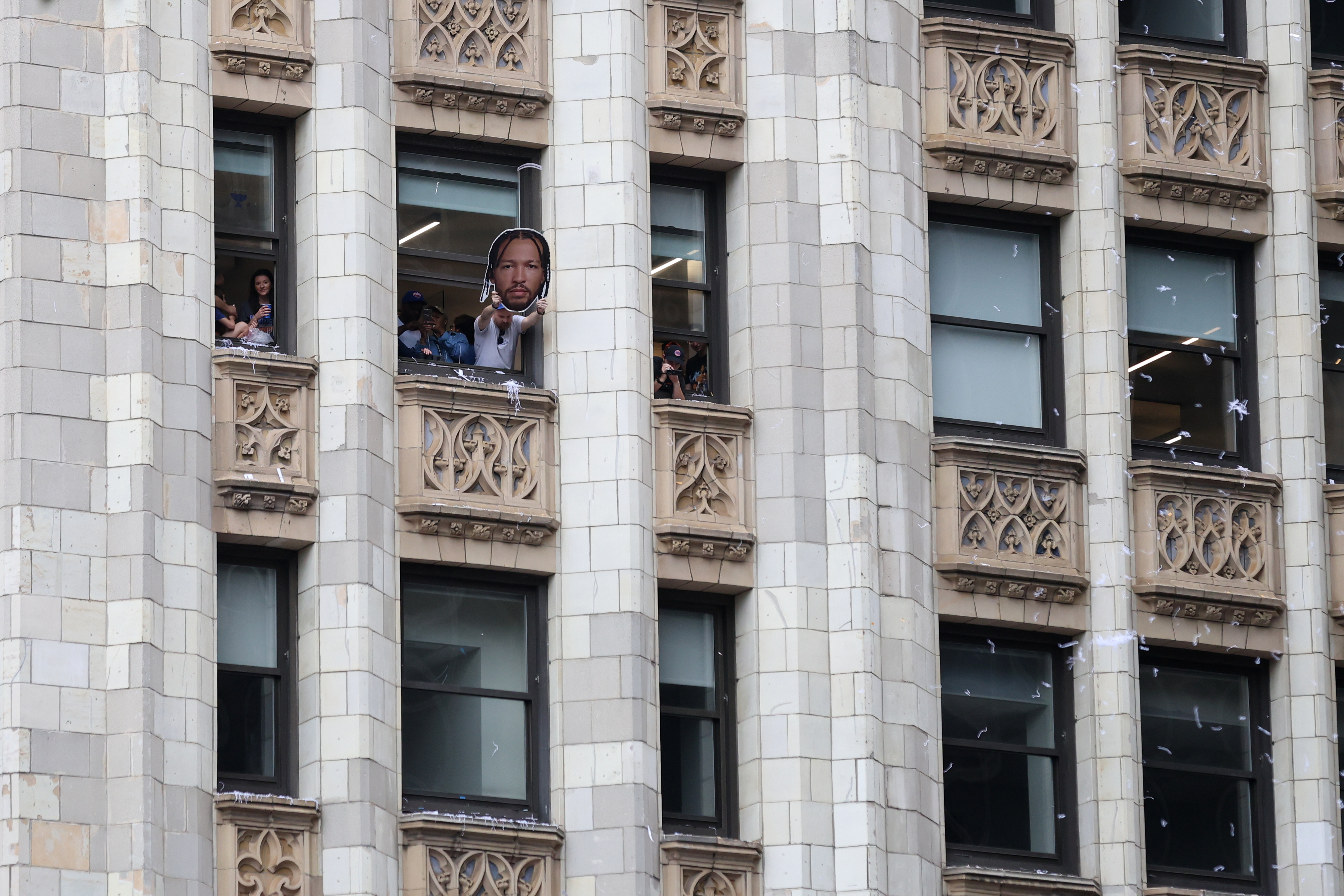 Fans watch from adjacent buildings during the New York Knicks' NBA championship parade Thursday, June 18, 2026, in New York