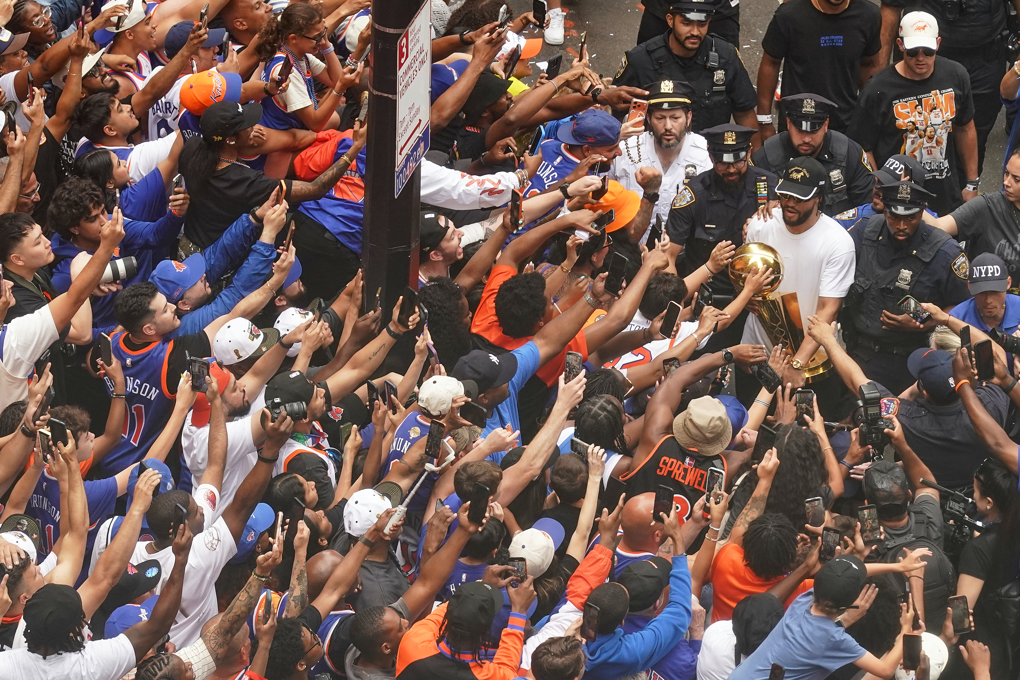 Jalen Brunson carries the trophy for fans during the ticker-tape parade on Broadway, in New York's "Canyon of Heroes," Thursday, June 18, 2026.