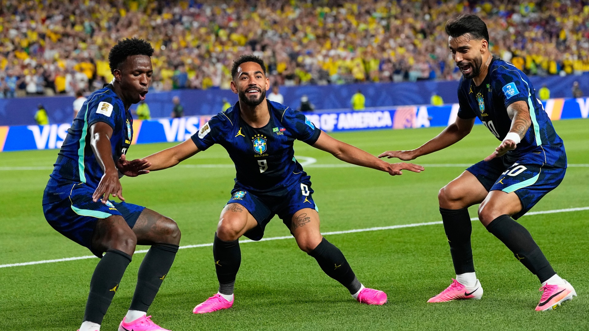 Brazil's Matheus Cunha (9) celebrates after scoring his side's second goal with Brazil's Vinicius Junior (7) and Lucas Paqueta (20) during the World Cup Group C soccer match.