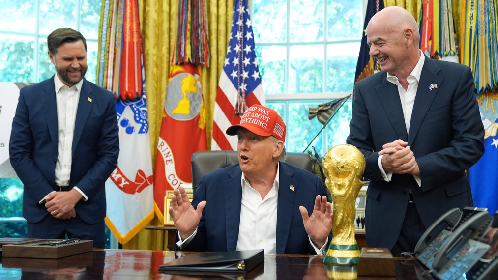 President Donald Trump speaks alongside the FIFA World Cup Winners Trophy as FIFA President Gianni Infantino, right, and Vice President JD Vance, left, watch in the Oval Office of the White House, Aug. 22, 2025, in Washington.