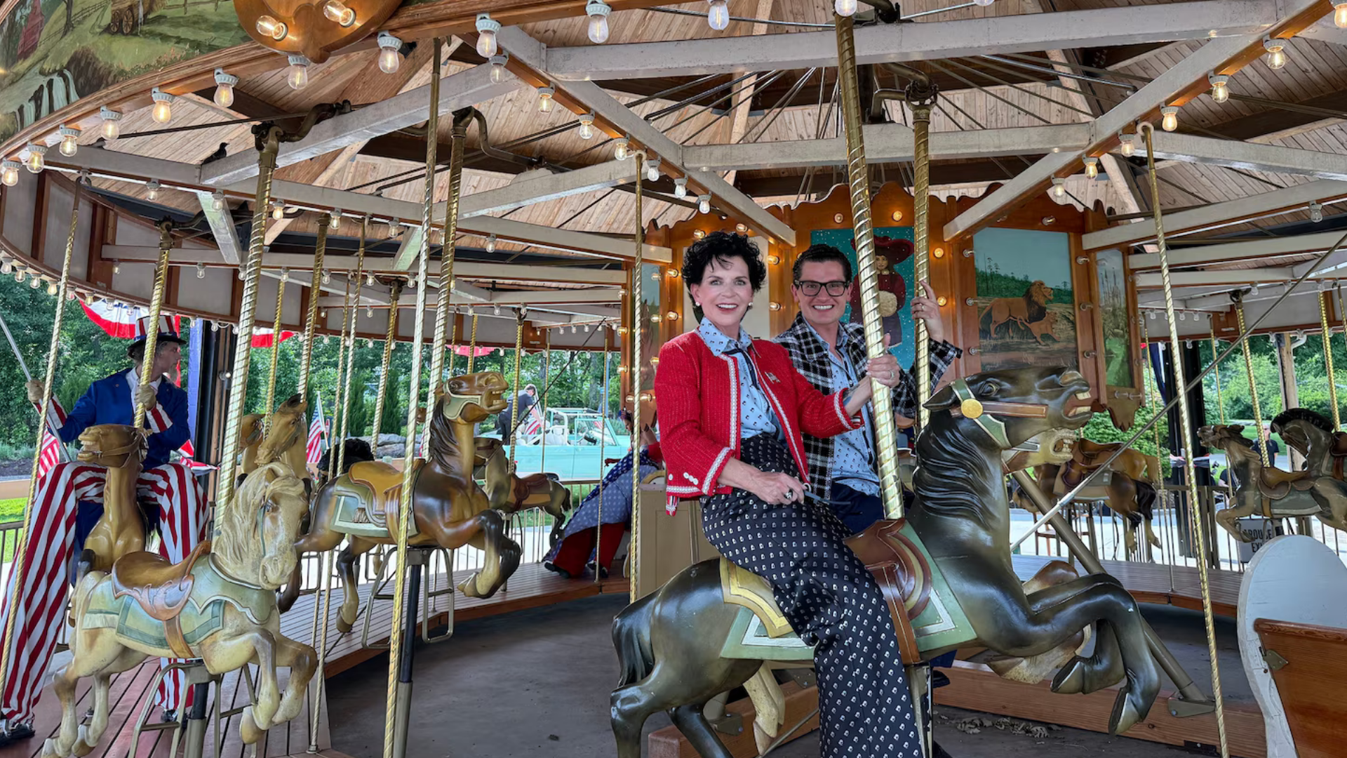 Nemacolin owner and CEO Maggie Hardy with her son and chief experiences officer, PJ Magerko Liquorice aboard the restored 1920s-era wooden carousel.