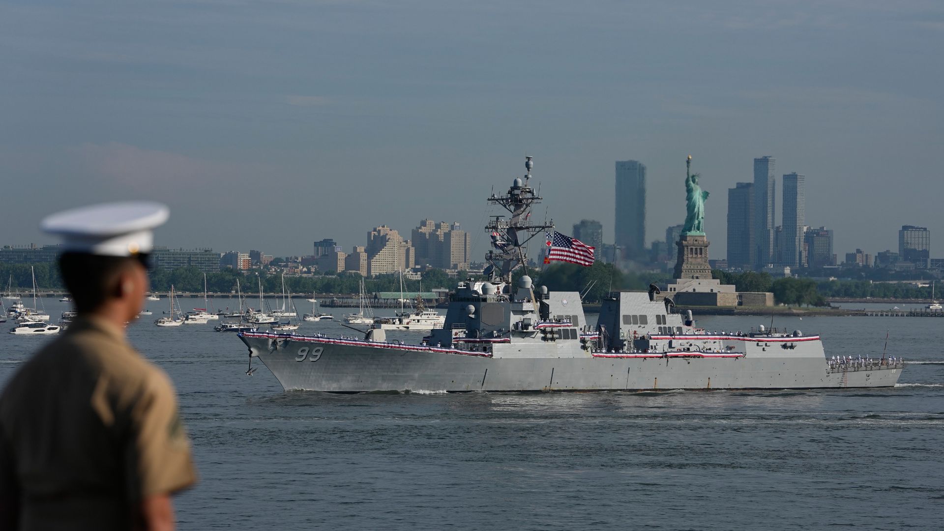 Military personnel watch the USS Farragut pass from the flight deck of the USS Kearsarge (LHD-3) in the New York harbor ahead of Sail250 in New York. (AP Photo/Frank Franklin II)