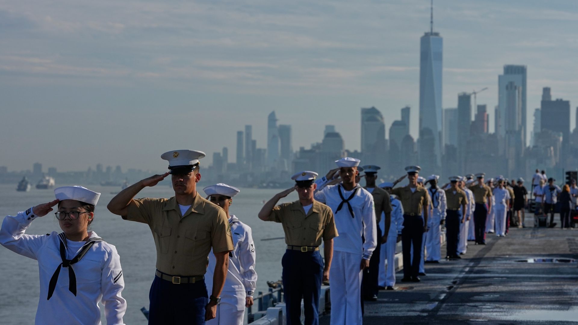Military personnel salute from the flight deck of the USS Kearsarge (LHD-3) in the New York harbor ahead of Sail250 in New York. (AP Photo/Frank Franklin II)