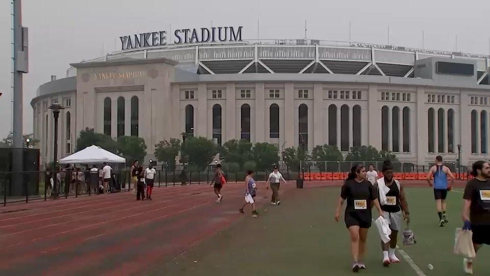 Runners push body to the finish line next to Yankee Stadium despite heat, poor air quality