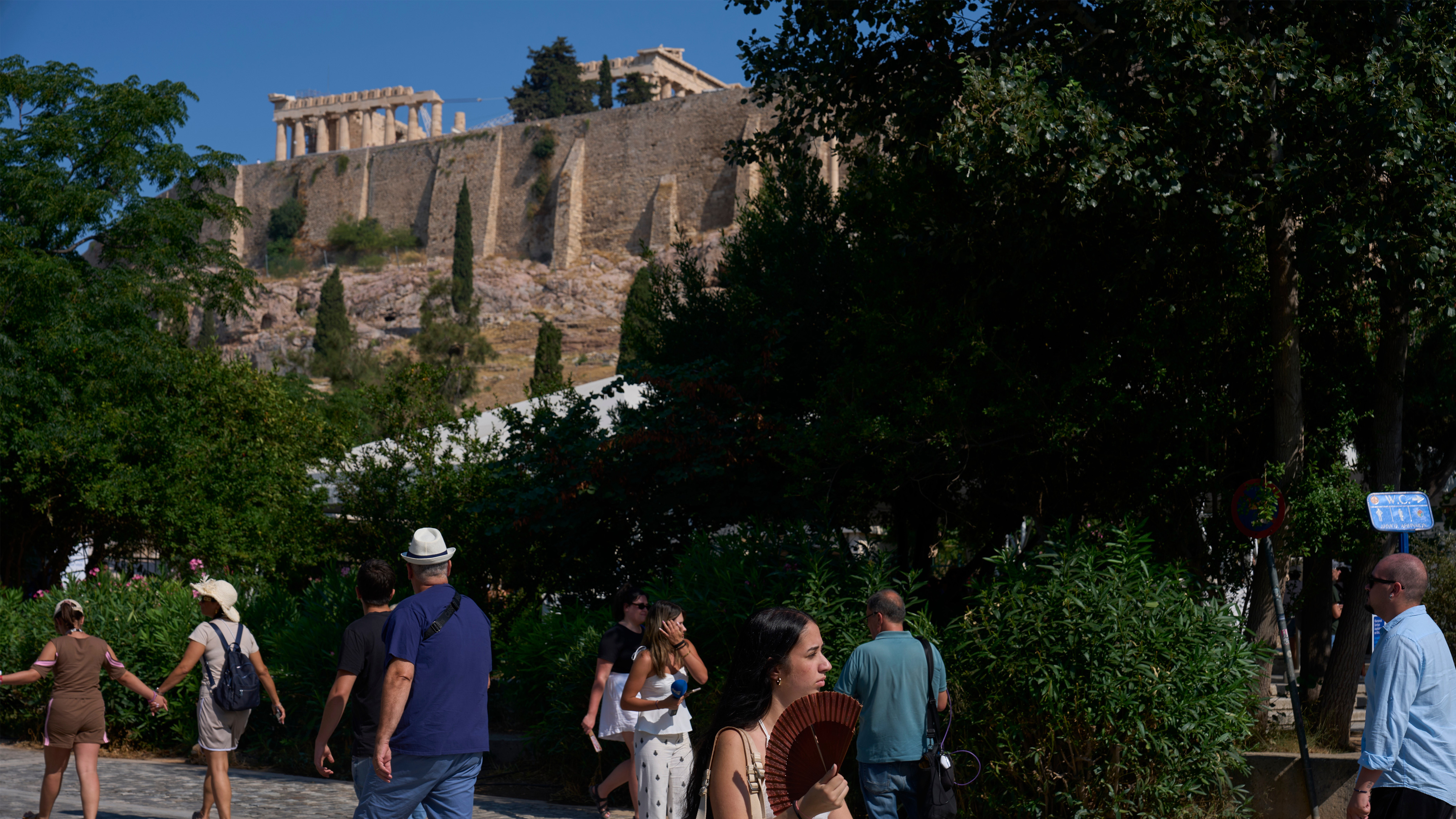 Tourists walk near the Acropolis in Athens, Greece, Tuesday, July 21, 2026.