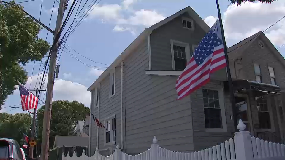 A flag is lowered to half-staff outside Rampersad's home in Ozone Park.