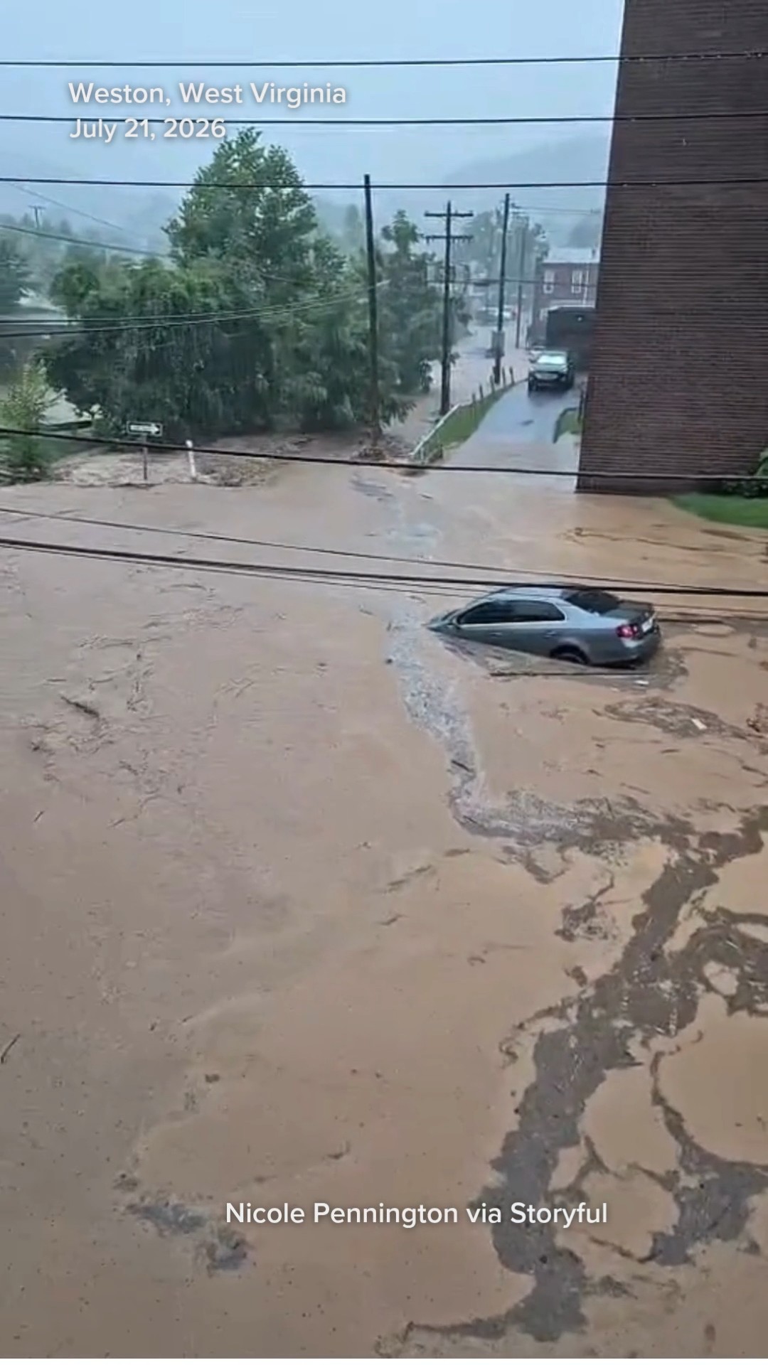 Insane Moment Muddy Floodwaters Sweep Sedan Along Inundated Street
