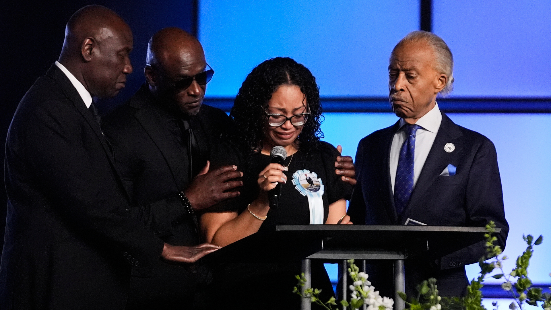 Christine Wonsley, center, is flanked by her husband Elmore, second from left, attorney Ben Crump, left, and Rev, Al Sharpton, right, during a memorial service for her son Nolan Xavier Wells, Monday, July 20, 2026, in Ocean Springs, Miss.