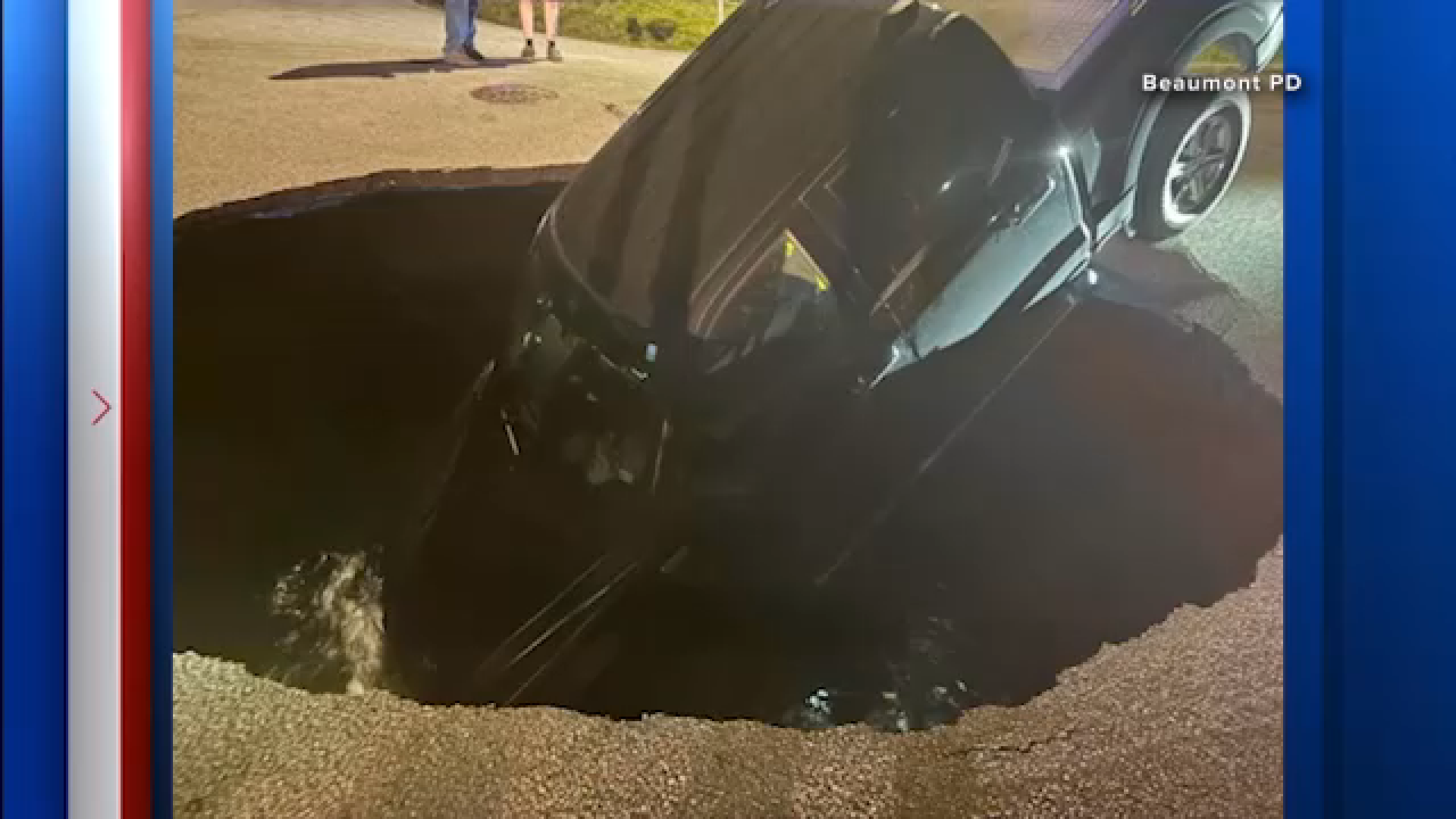 An image shared by the Beaumont Police Department shows a truck inside a hole in the road filled with water.